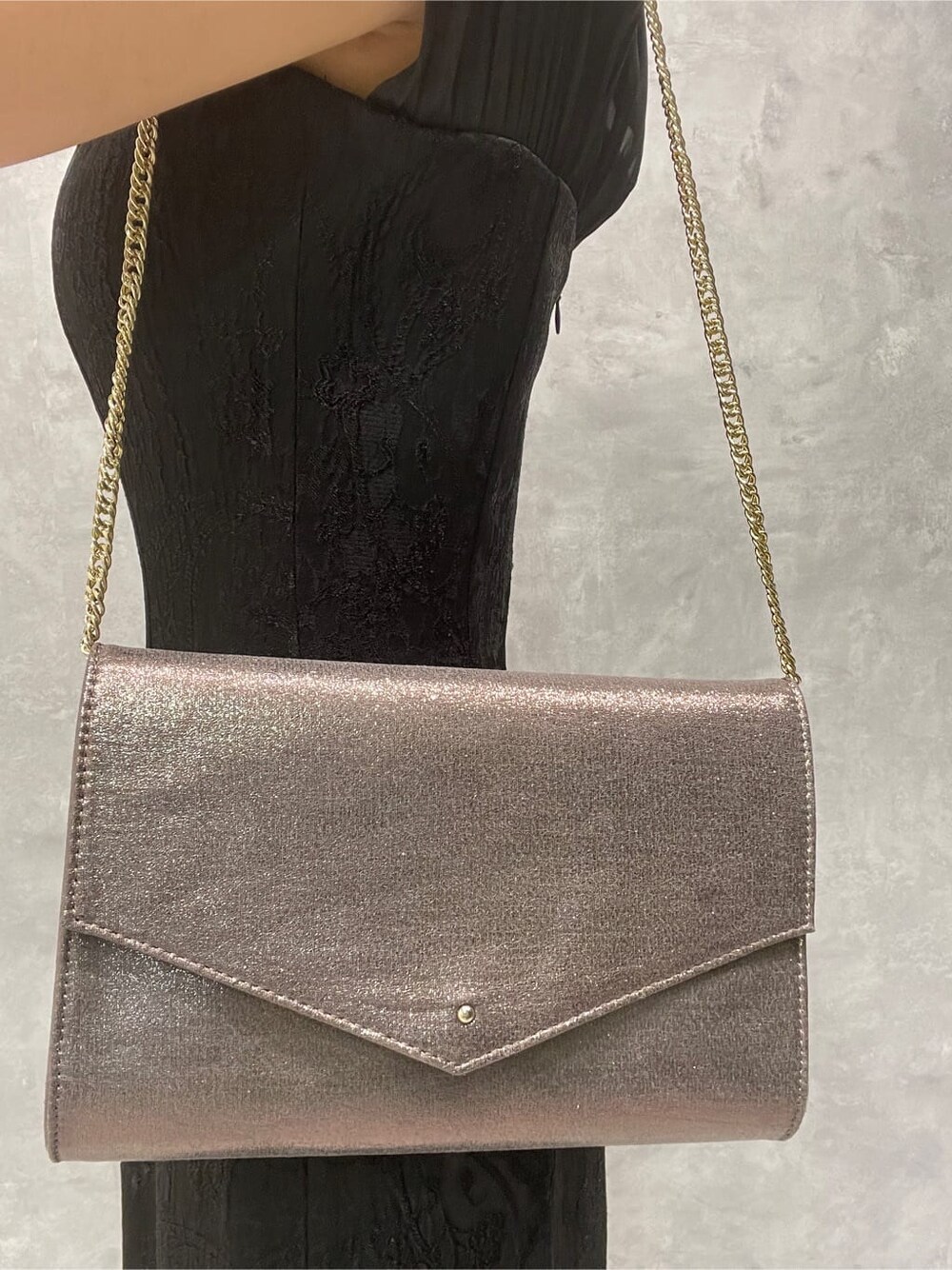 シルバー系のパンプス、シルバー系のクラッチバッグ、ブラック系のドレスを着用したレディースの夏コーディネートの8枚目の写真