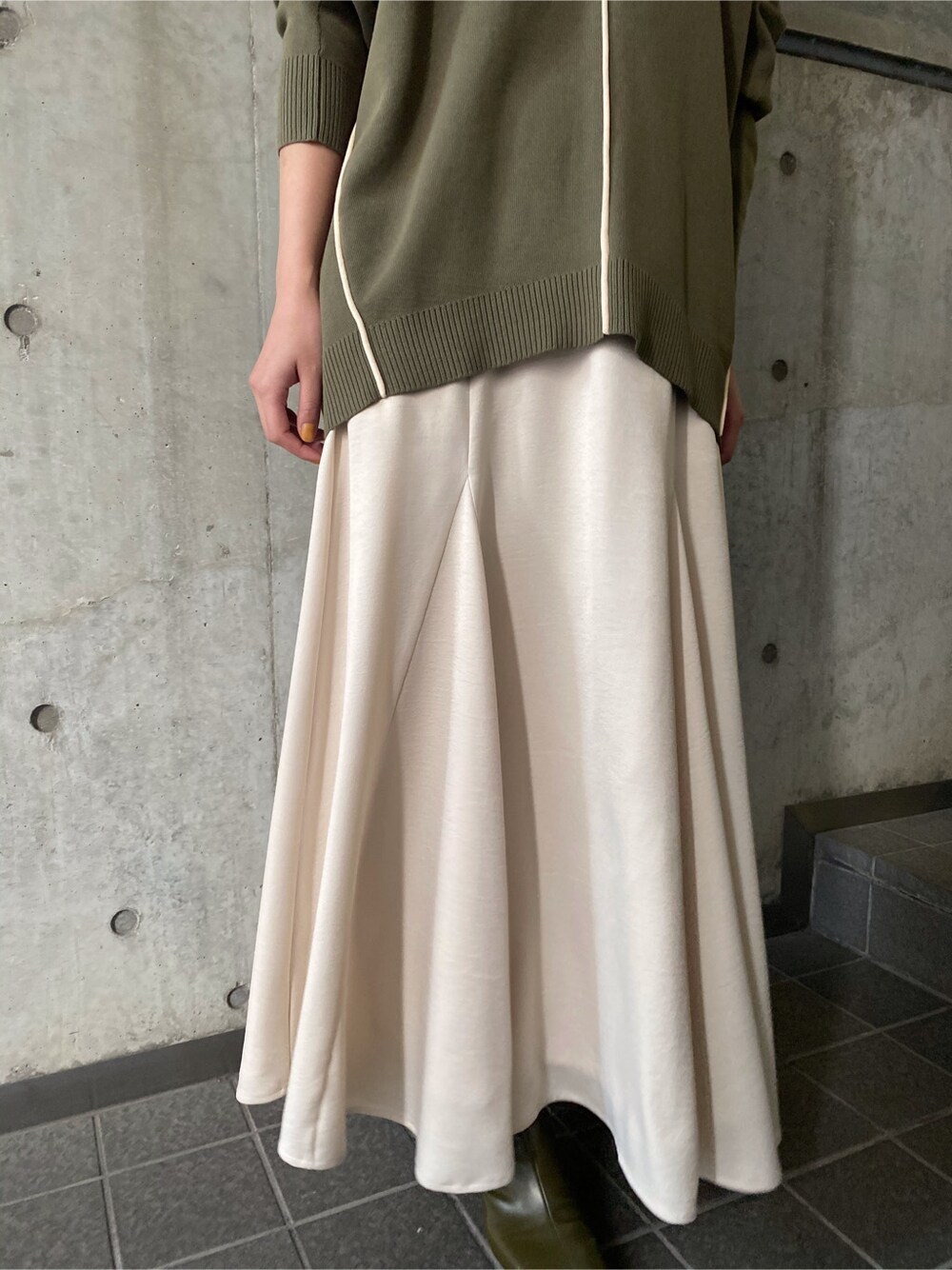 ホワイト系のスカート、ベージュ系のブーツ、ベージュ系のニット/セーターを着用したレディースの冬コーディネートの5枚目の写真