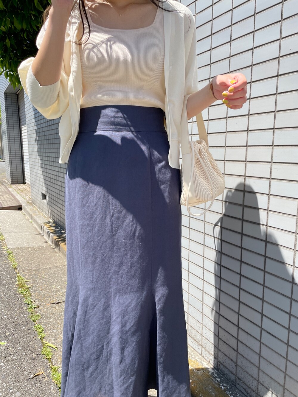 ブルー系のスカート、ホワイト系のカーディガン/ボレロ、ホワイト系のニット/セーターを着用したレディースの春コーディネートの7枚目の写真