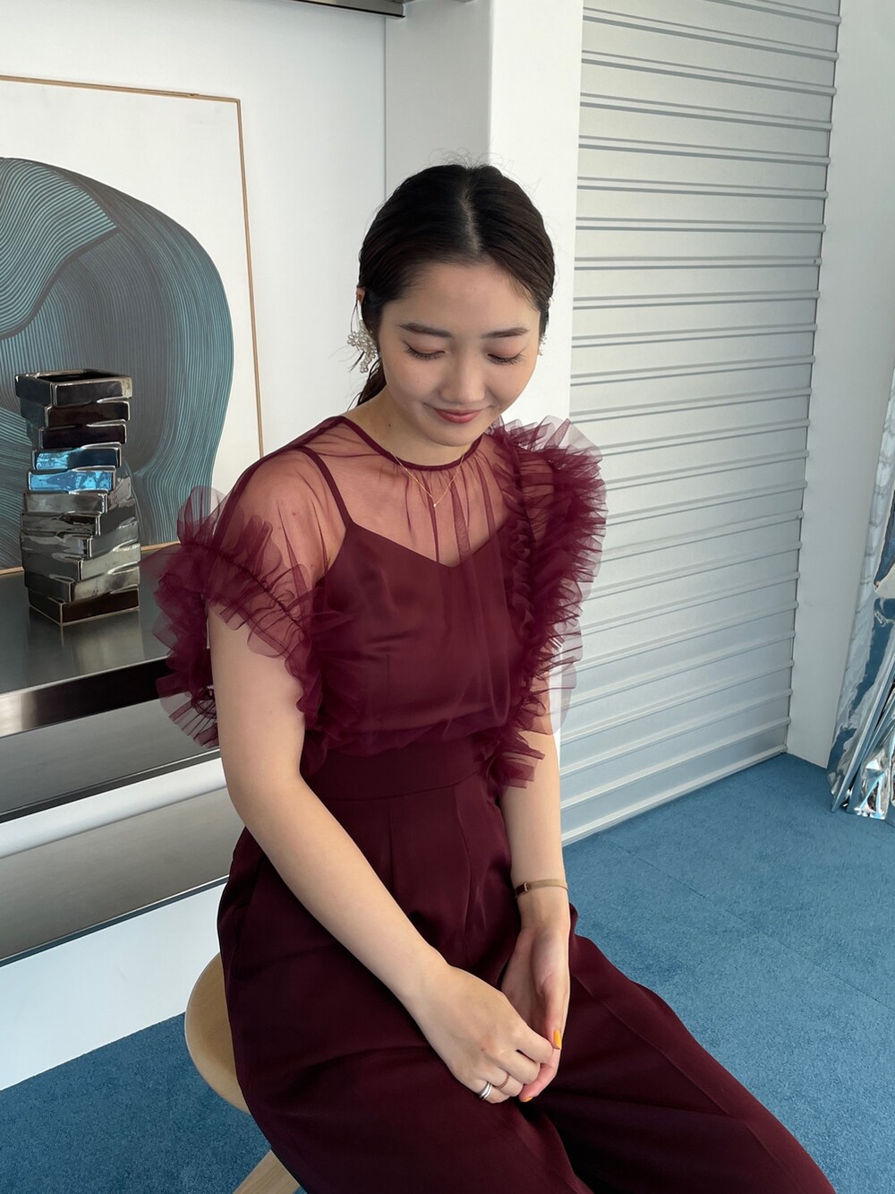 ゴールド系のパンプス、レッド系のパンツドレスを着用したレディースの春コーディネートの6枚目の写真