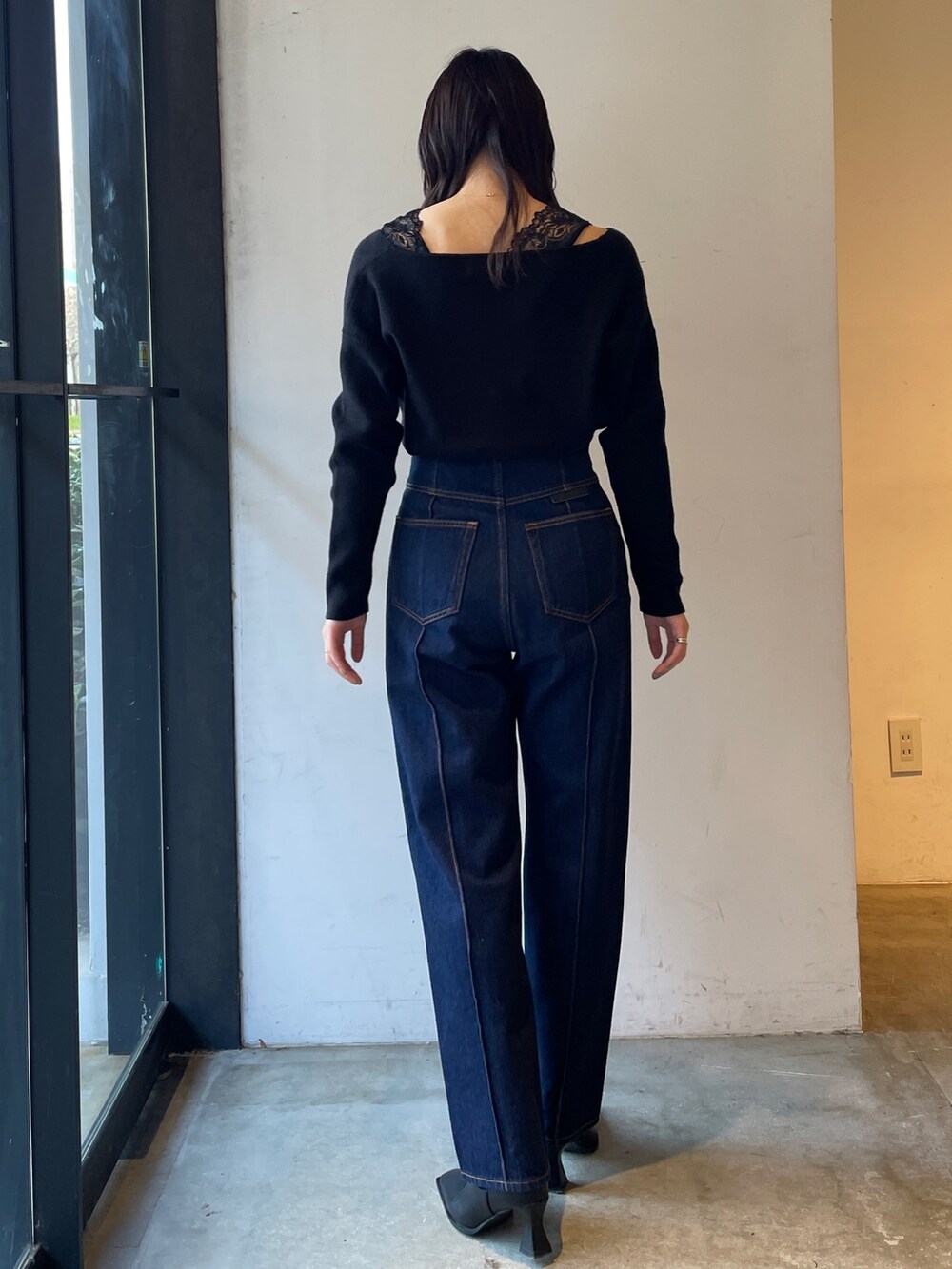 ブラック系のブーツ、ブルー系のデニムパンツ、ブラック系のニット/セーターを着用したレディースの冬コーディネートの4枚目の写真