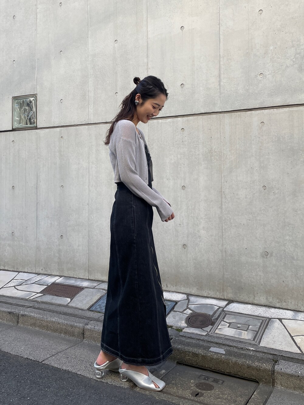 ブラック系のワンピース、シルバー系のカーディガン/ボレロ、シルバー系のパンプスを着用したレディースの冬コーディネートの3枚目の写真