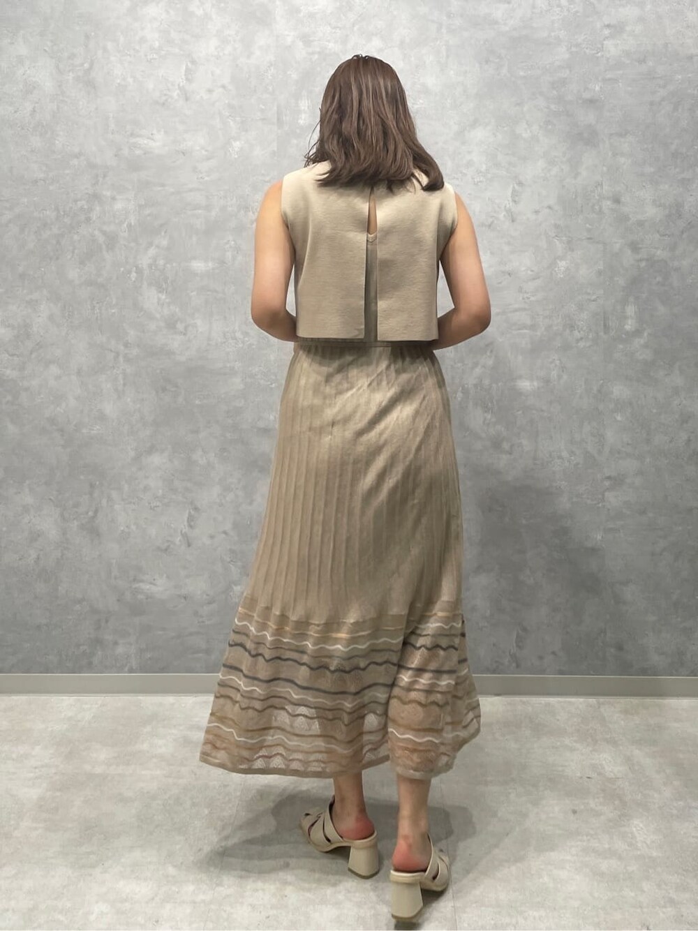 ベージュ系のワンピース、ホワイト系のサンダルを着用したレディースの夏コーディネートの4枚目の写真