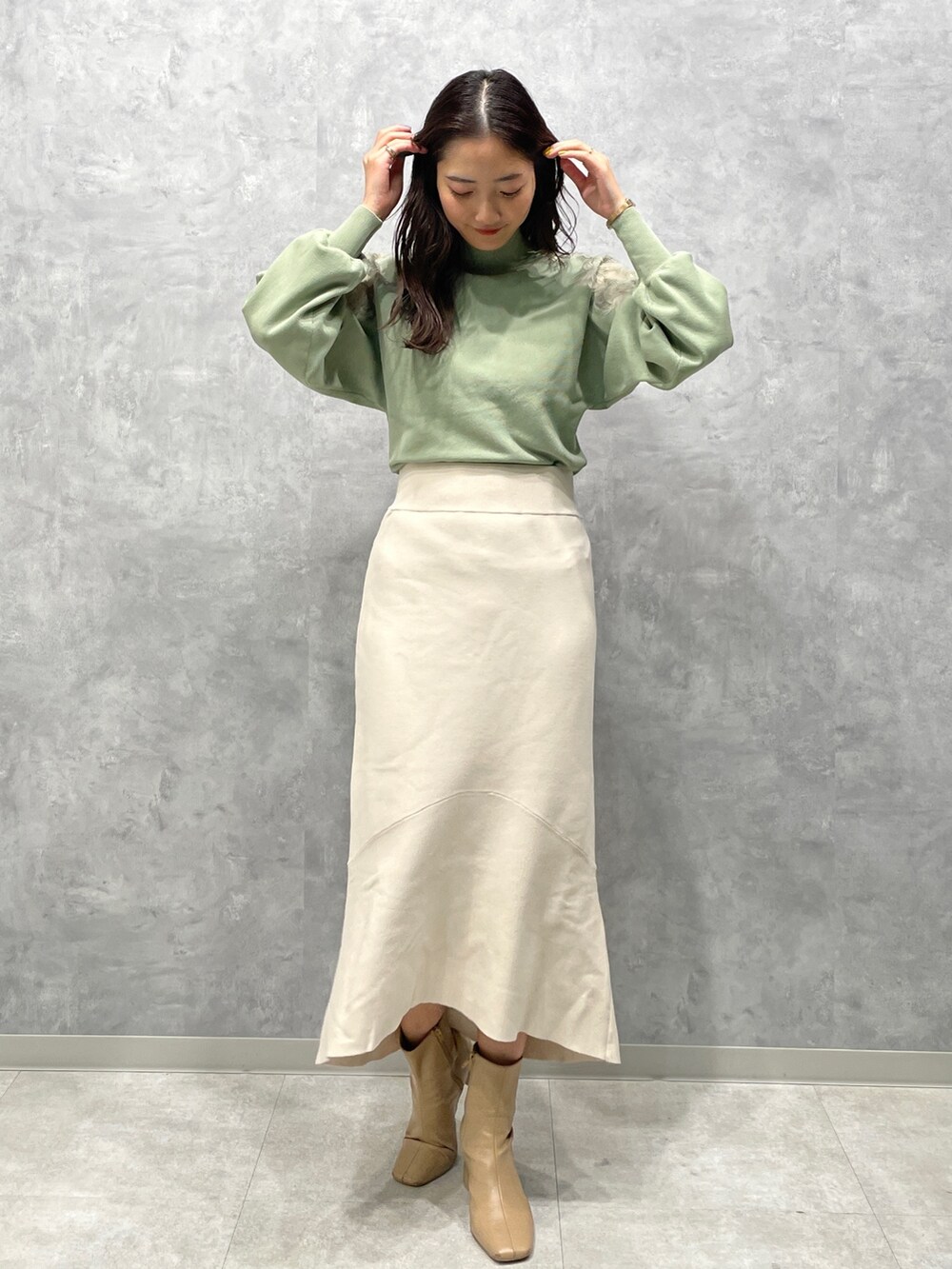 ベージュ系のブーツ、グリーン系のニット/セーター、ベージュ系のその他アウターを着用したレディースの冬コーディネートの4枚目の写真