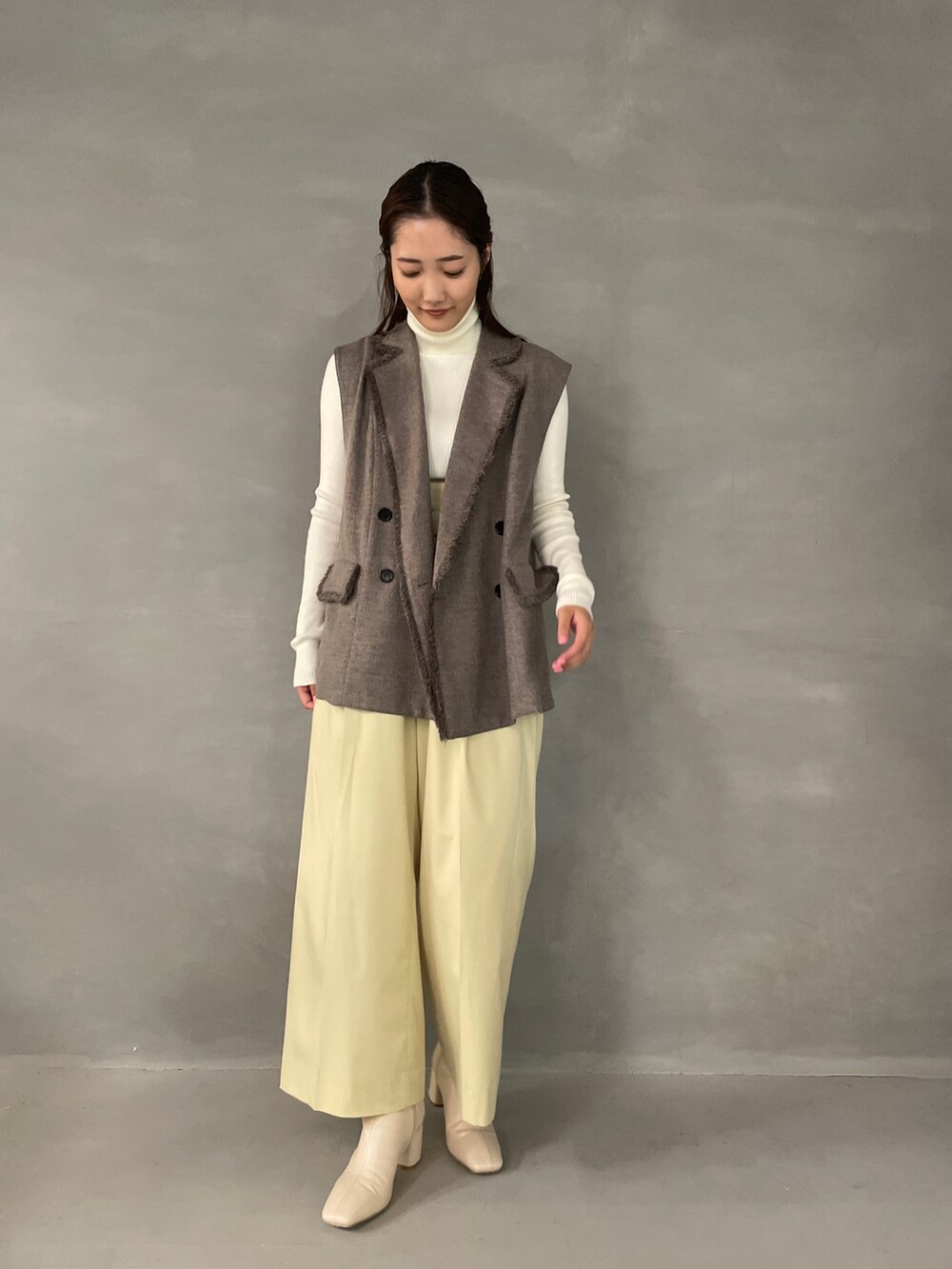 イエロー系のその他パンツ、ホワイト系のブーツ、グレー系のベストを着用したレディースの夏コーディネートの2枚目の写真