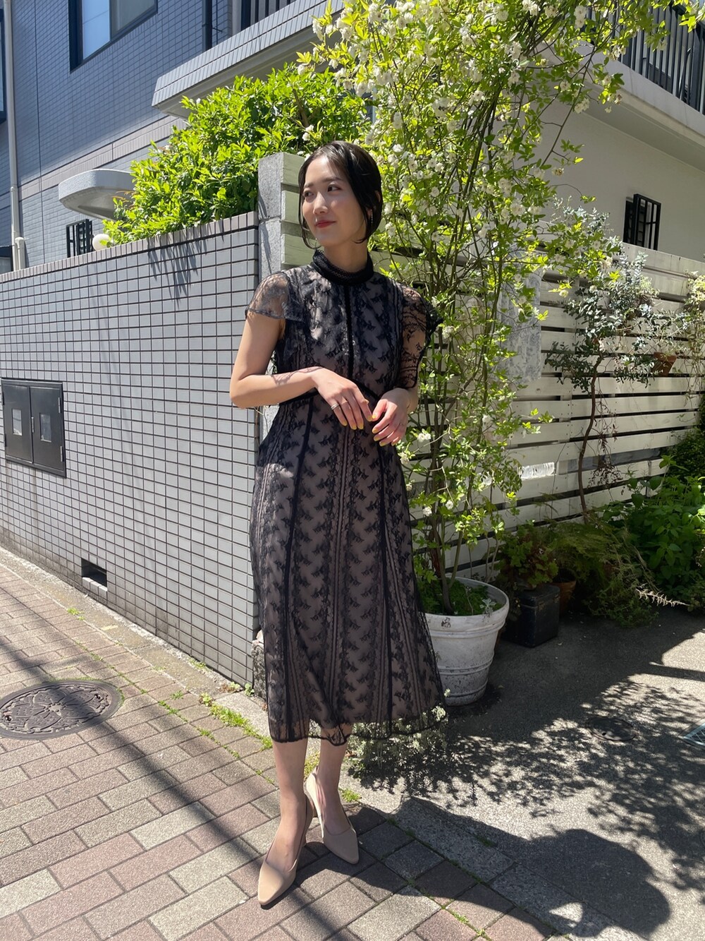 ゴールド系のパンプス、ブラック系のドレスを着用したレディースの夏コーディネートの4枚目の写真