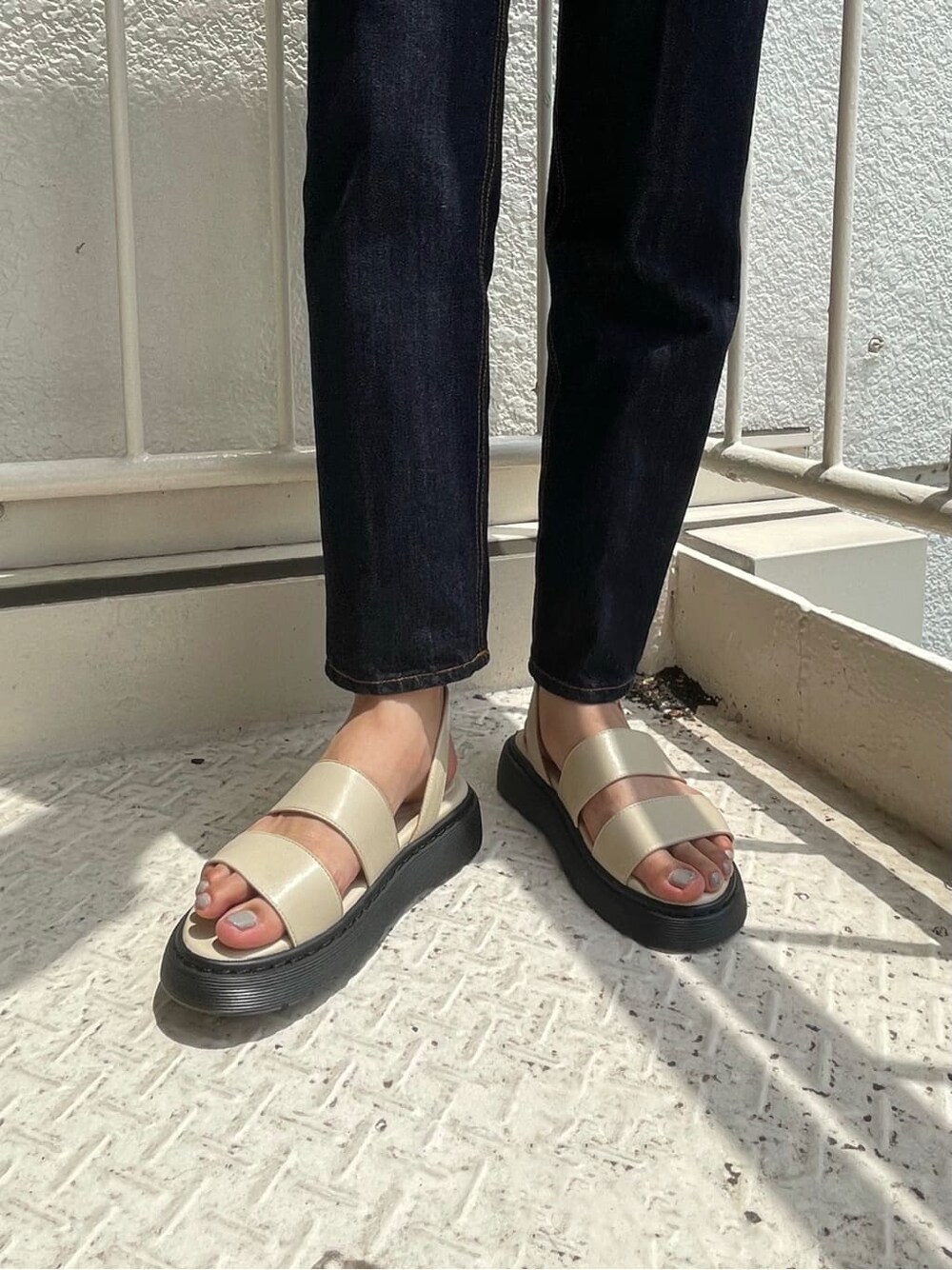 ブルー系のデニムパンツ、ホワイト系のサンダル、ベージュ系のニット/セーターを着用したレディースの夏コーディネートの7枚目の写真