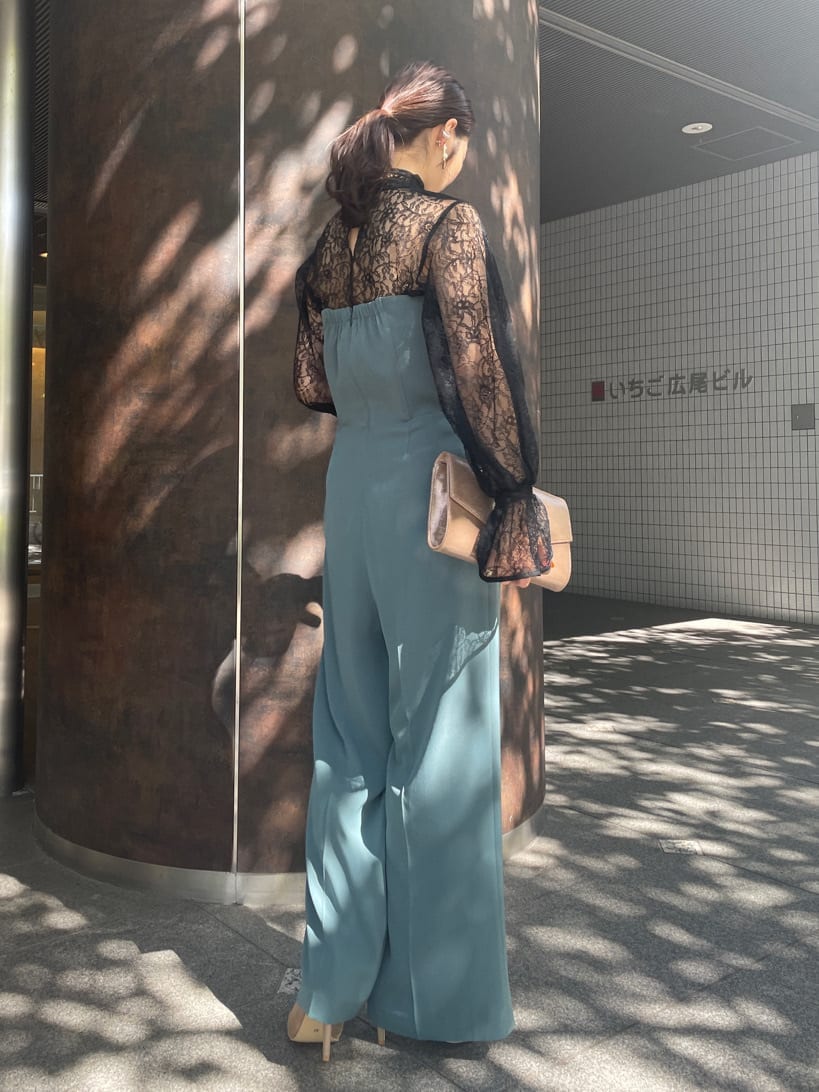 ゴールド系のクラッチバッグ、ゴールド系のパンプス、ブラック系のシャツ/ブラウスを着用したレディースの秋コーディネートの6枚目の写真