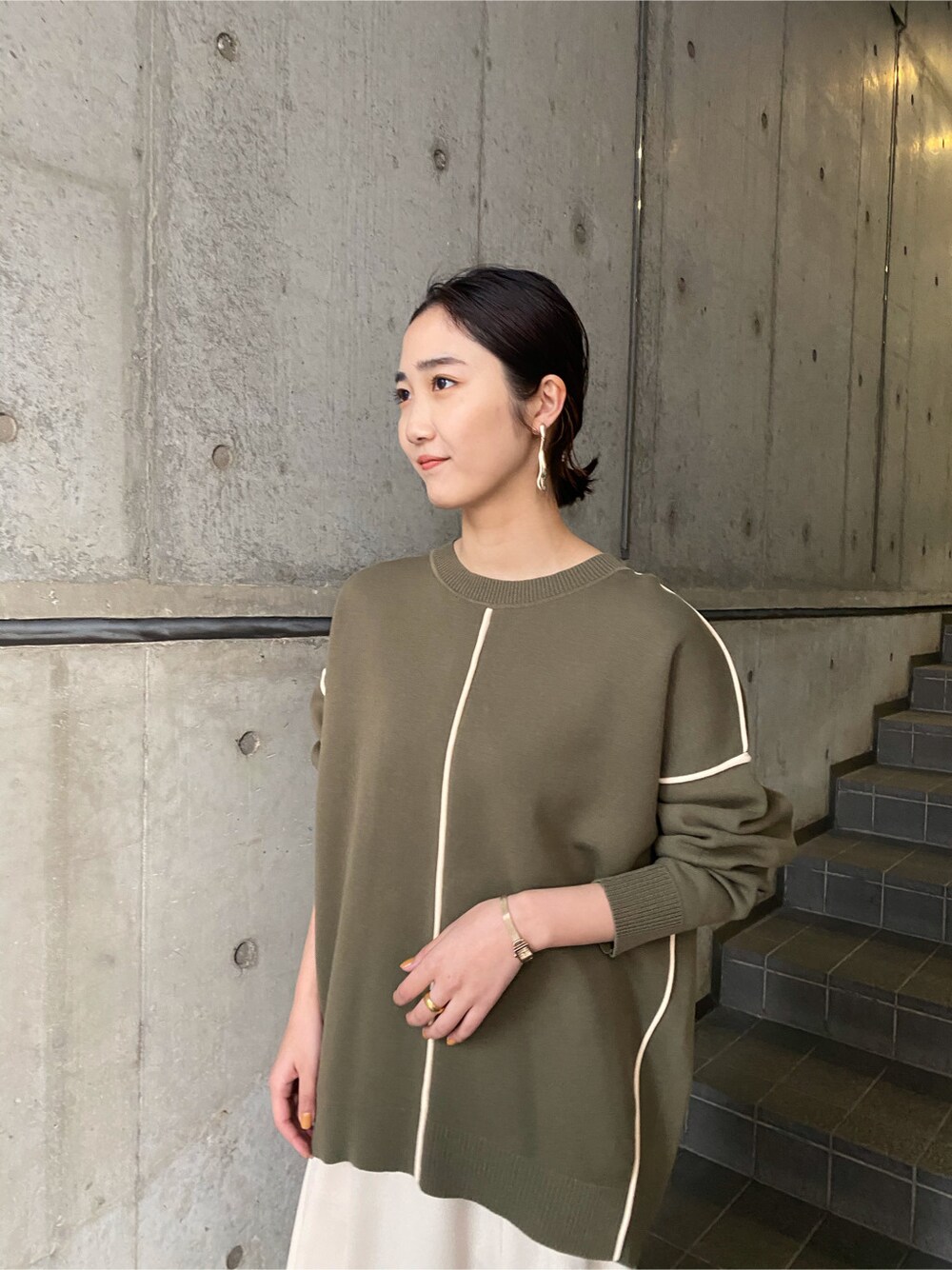 ホワイト系のスカート、ベージュ系のブーツ、ベージュ系のニット/セーターを着用したレディースの冬コーディネートの3枚目の写真