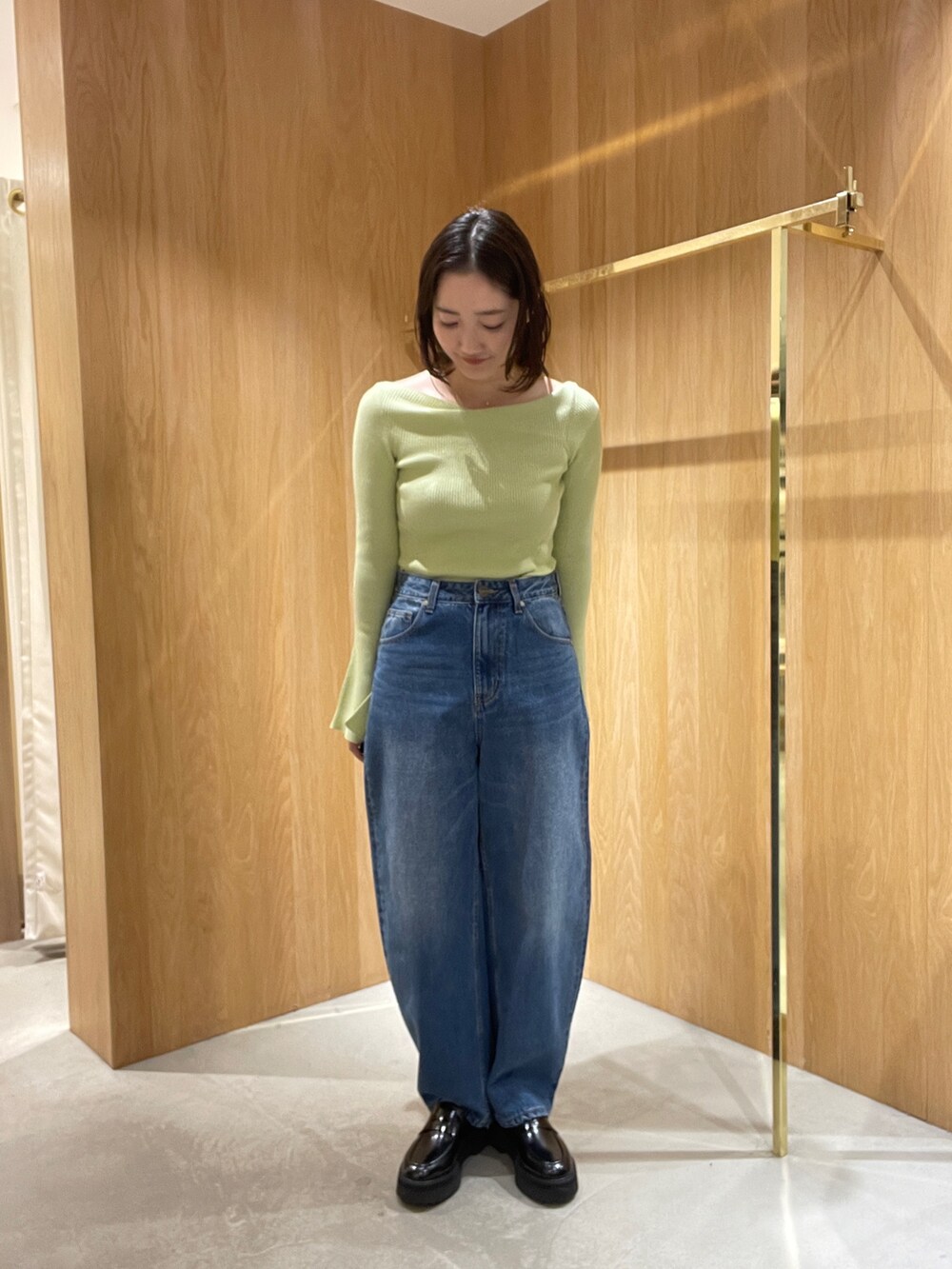 ブルー系のデニムパンツ、ホワイト系のブルゾン、グリーン系のニット/セーターを着用したレディースの秋コーディネートの5枚目の写真