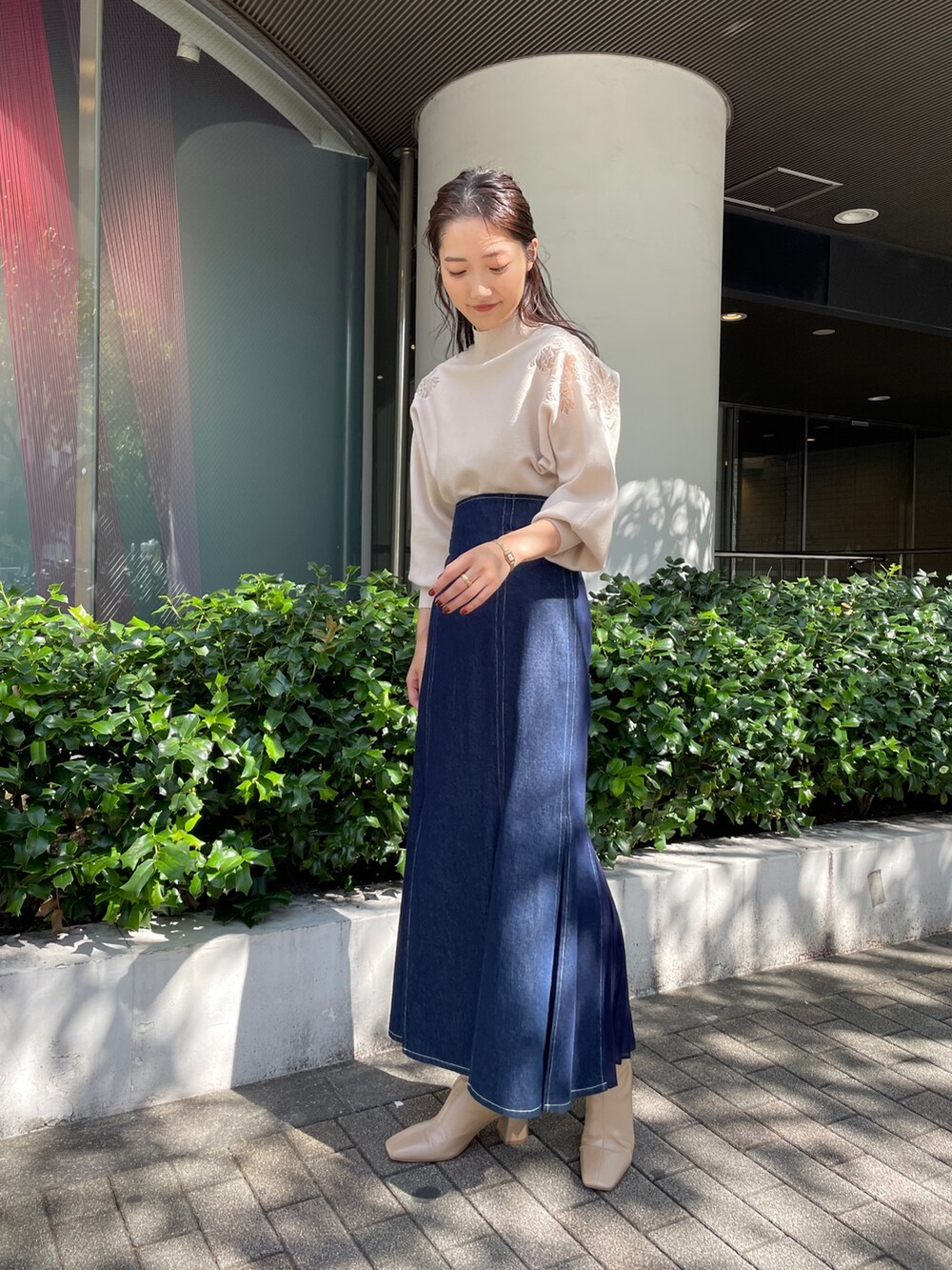 ベージュ系のブーツ、ブルー系のスカート、ホワイト系のニット/セーターを着用したレディースの秋コーディネートの7枚目の写真