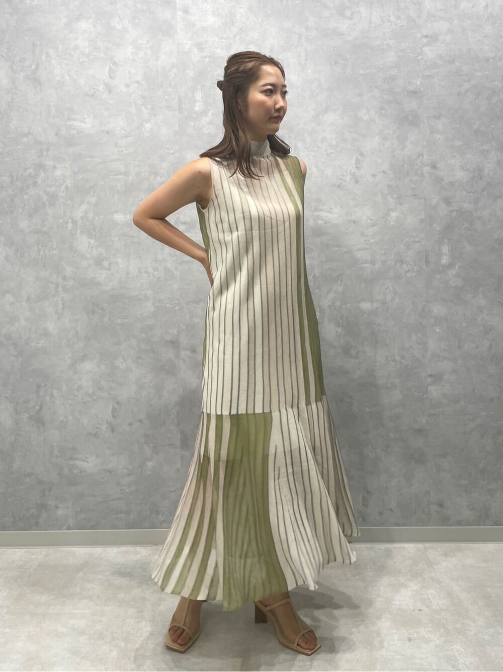 グリーン系のワンピース、ベージュ系のサンダルを着用したレディースの夏コーディネートの2枚目の写真