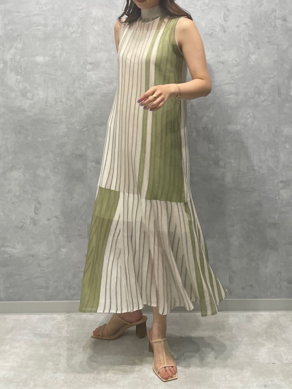 グリーン系のワンピース、ベージュ系のサンダルを着用したレディースの夏コーディネートの3枚目の写真