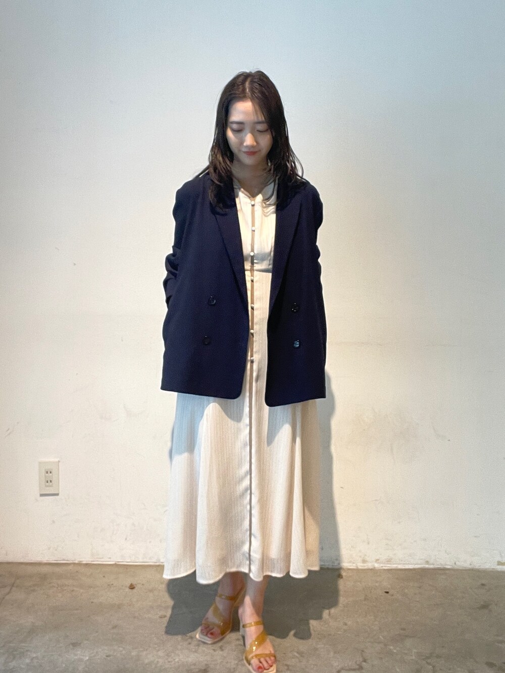 イエロー系のサンダル、ブルー系のテーラードジャケット、ホワイト系のワンピースを着用したレディースの夏コーディネートの3枚目の写真