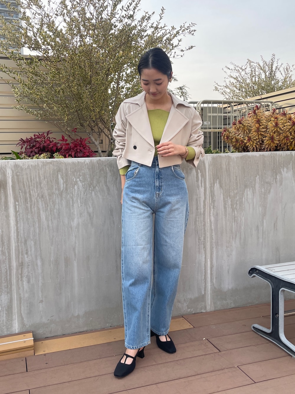 ブルー系のデニムパンツ、ホワイト系のトレンチコート、グリーン系のニット/セーターを着用したレディースの冬コーディネートの3枚目の写真