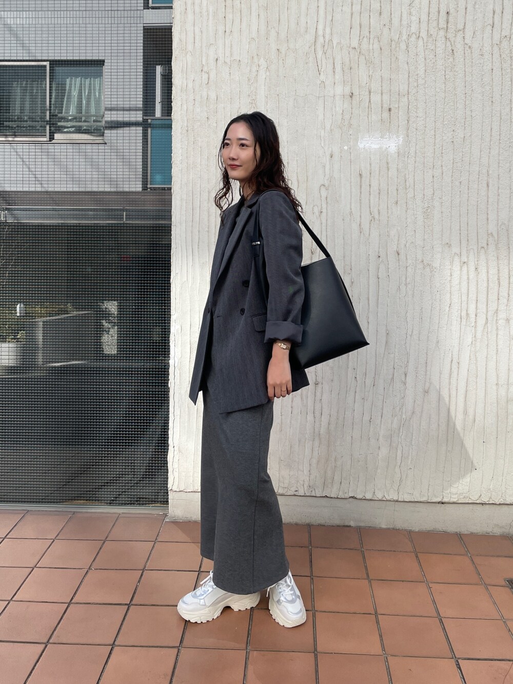 ホワイト系のスニーカー、グレー系のワンピース、グレー系のテーラードジャケットを着用したレディースの冬コーディネートの4枚目の写真