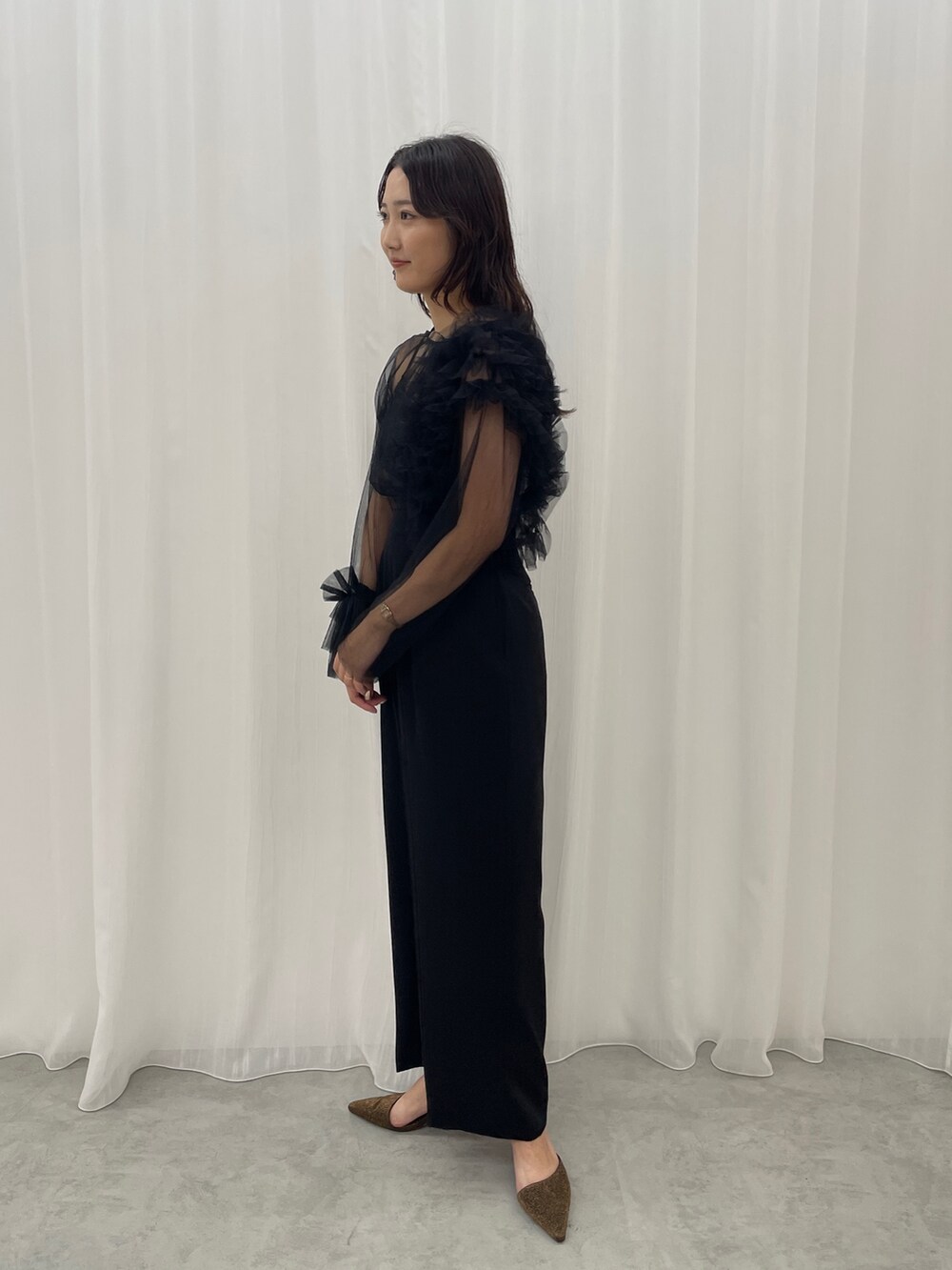 ブラック系のパンツドレス、その他のパンプスを着用したレディースの秋コーディネートの4枚目の写真