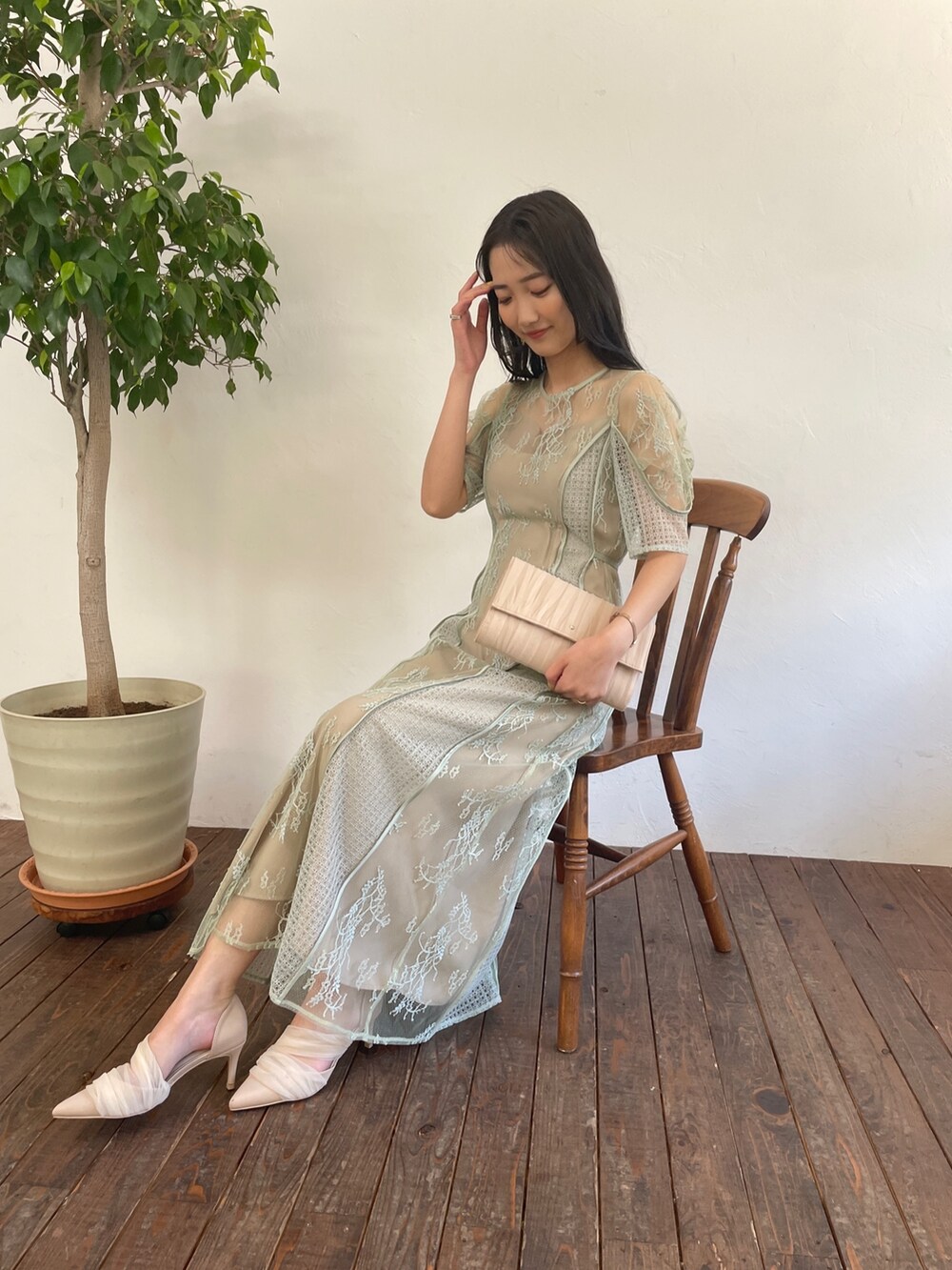 グリーン系のドレス、ベージュ系のハンドバッグ、ベージュ系のパンプスを着用したレディースの春コーディネートの8枚目の写真