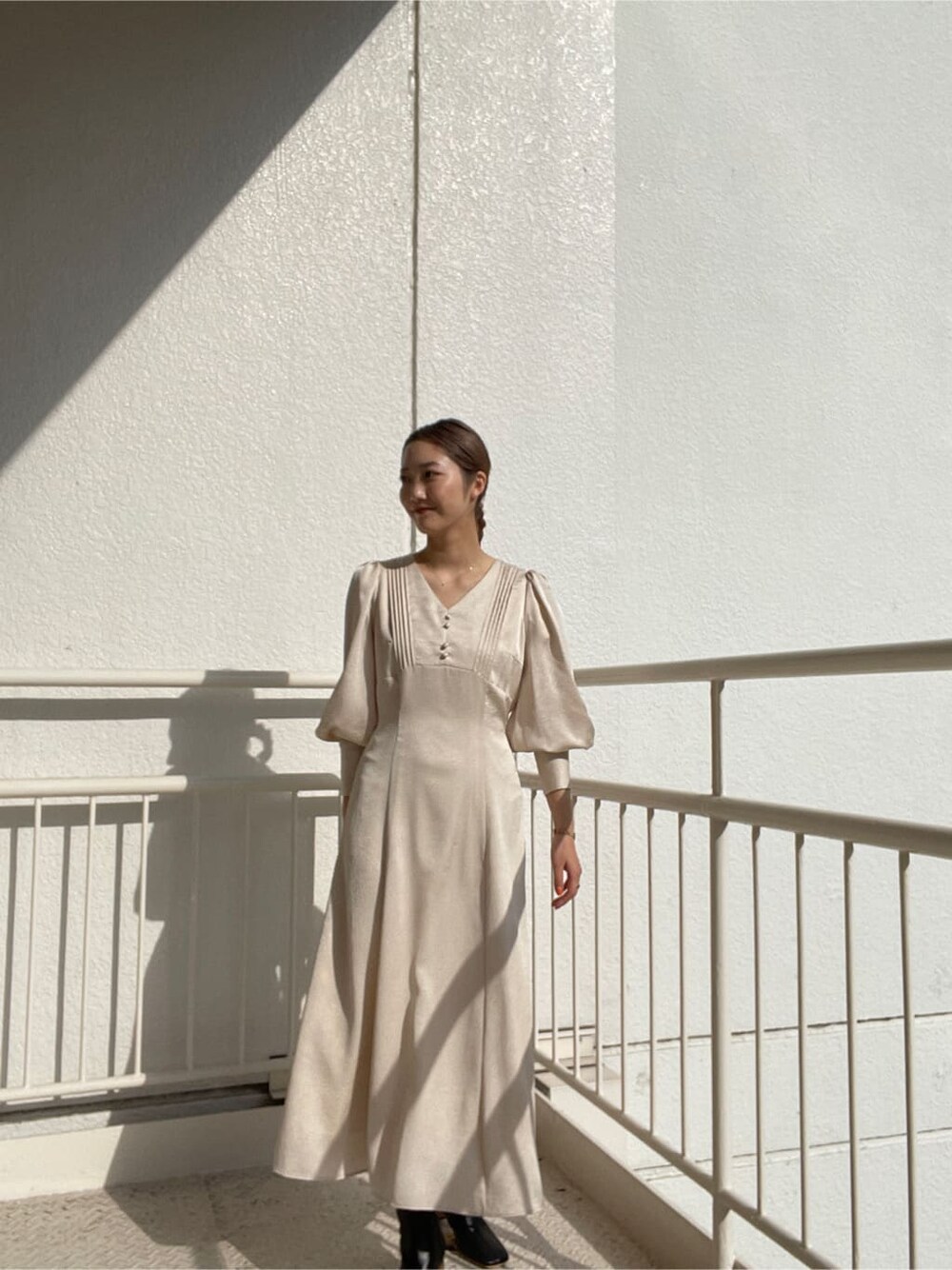 ブラック系のその他シューズ、ブラック系のその他アウター、ホワイト系のワンピースを着用したレディースの冬コーディネートの2枚目の写真