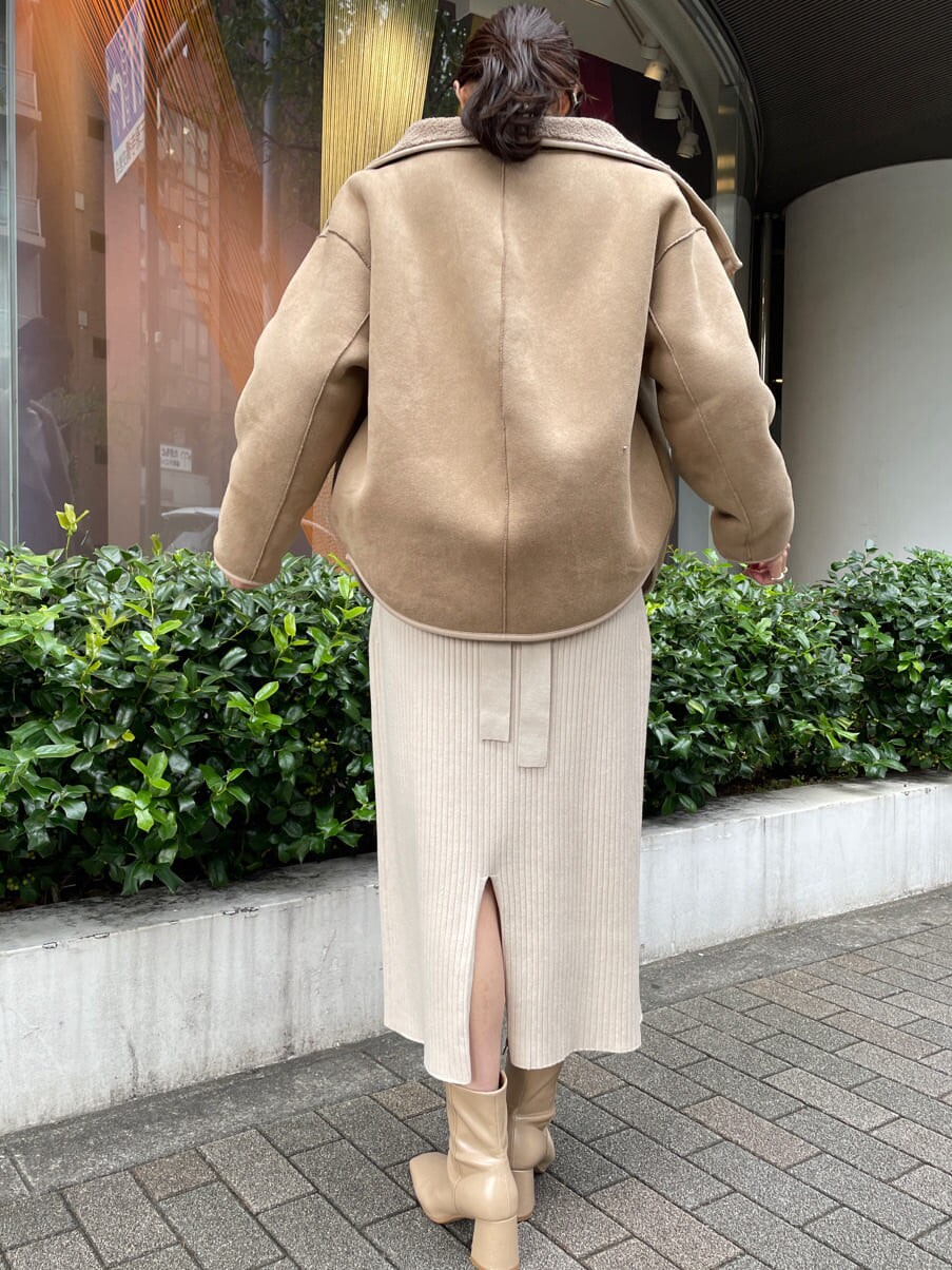 ベージュ系のブーツ、ブラウン系のブルゾン、ホワイト系のワンピースを着用したレディースの秋コーディネートの4枚目の写真