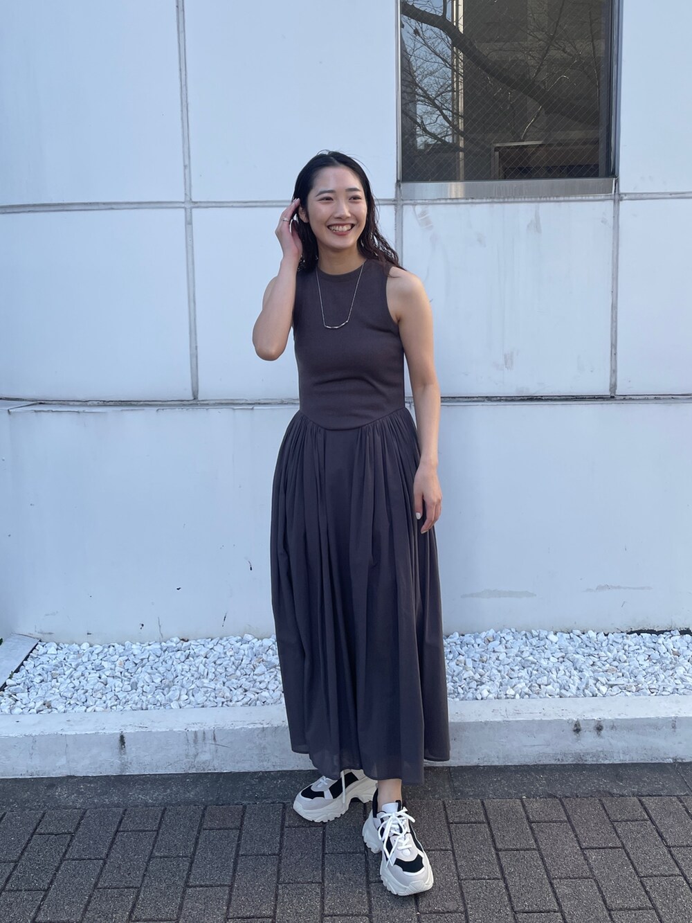 グレー系のワンピース、ブラック系のスニーカーを着用したレディースの春コーディネートの4枚目の写真