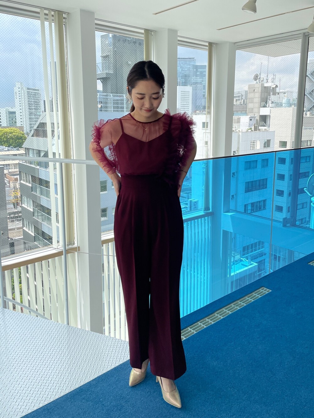 ゴールド系のパンプス、レッド系のパンツドレスを着用したレディースの春コーディネートの4枚目の写真