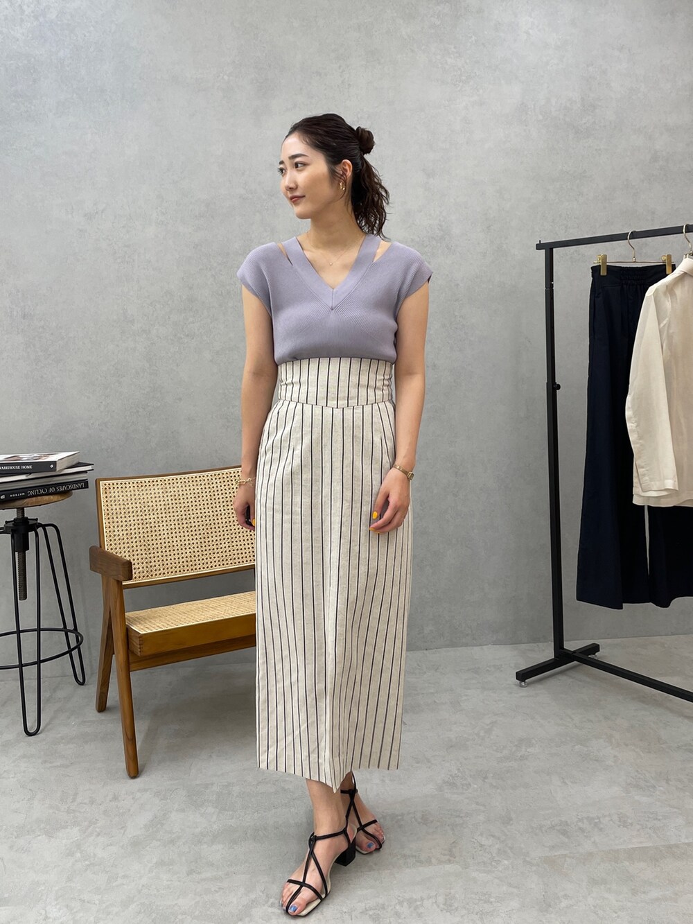 グレー系のスカート、ホワイト系のテーラードジャケット、ブルー系のニット/セーターを着用したレディースの春コーディネートの6枚目の写真