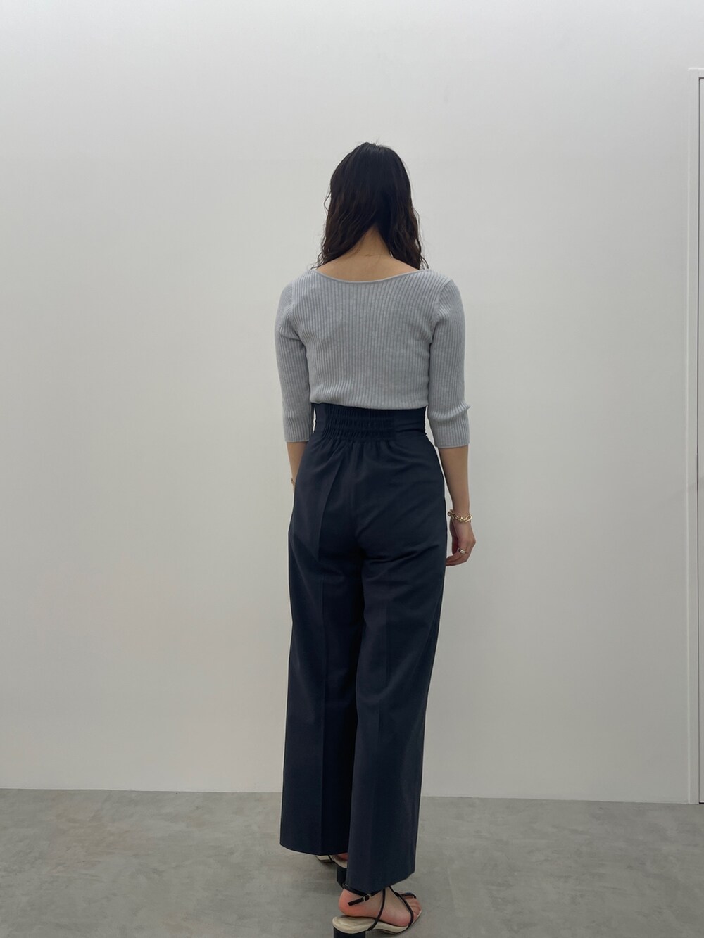 ブラック系のサンダル、ブルー系のスラックス、ブルー系のニット/セーターを着用したレディースの春コーディネートの5枚目の写真