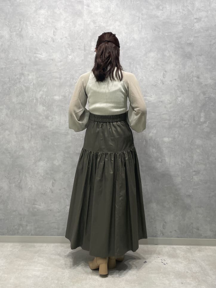 ベージュ系のスカート、ベージュ系のブーツ、グリーン系のニット/セーターを着用したレディースの夏コーディネートの6枚目の写真