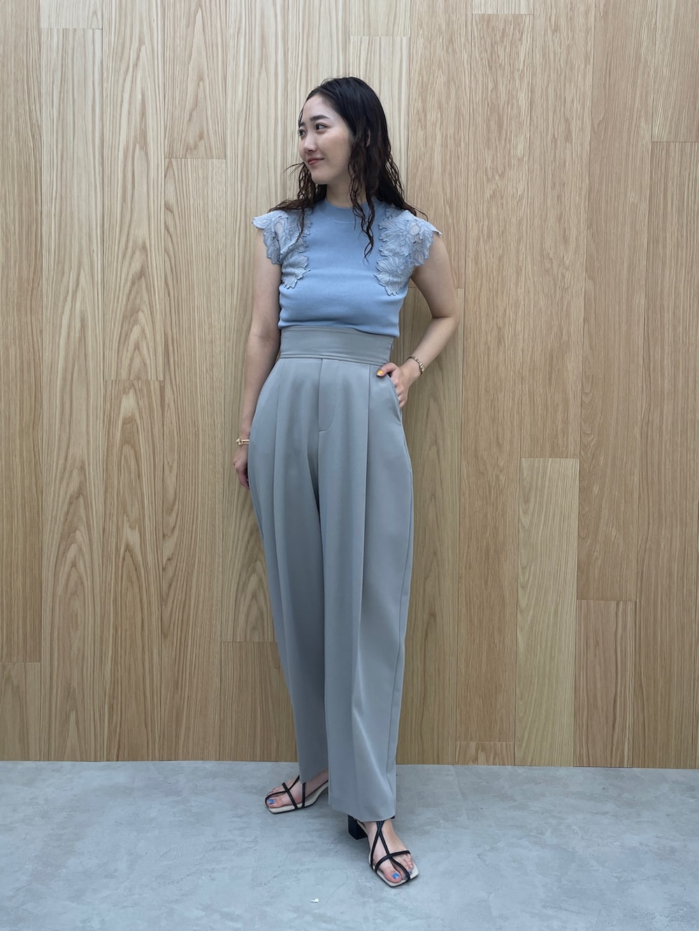 ブルー系のニット/セーター、ブラック系のサンダル、グレー系のその他パンツを着用したレディースの夏コーディネートの2枚目の写真