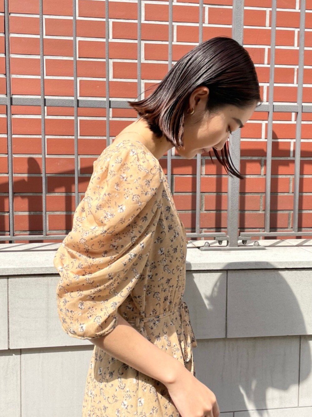 イエロー系のワンピース、その他のパンプスを着用したレディースの春コーディネートの2枚目の写真