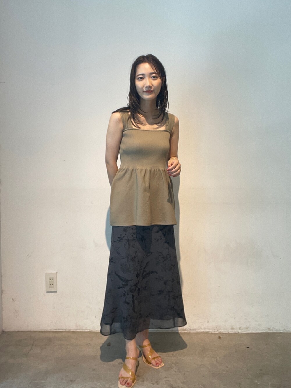 グレー系のスカート、イエロー系のサンダル、ベージュ系のニット/セーターを着用したレディースの夏コーディネートの4枚目の写真