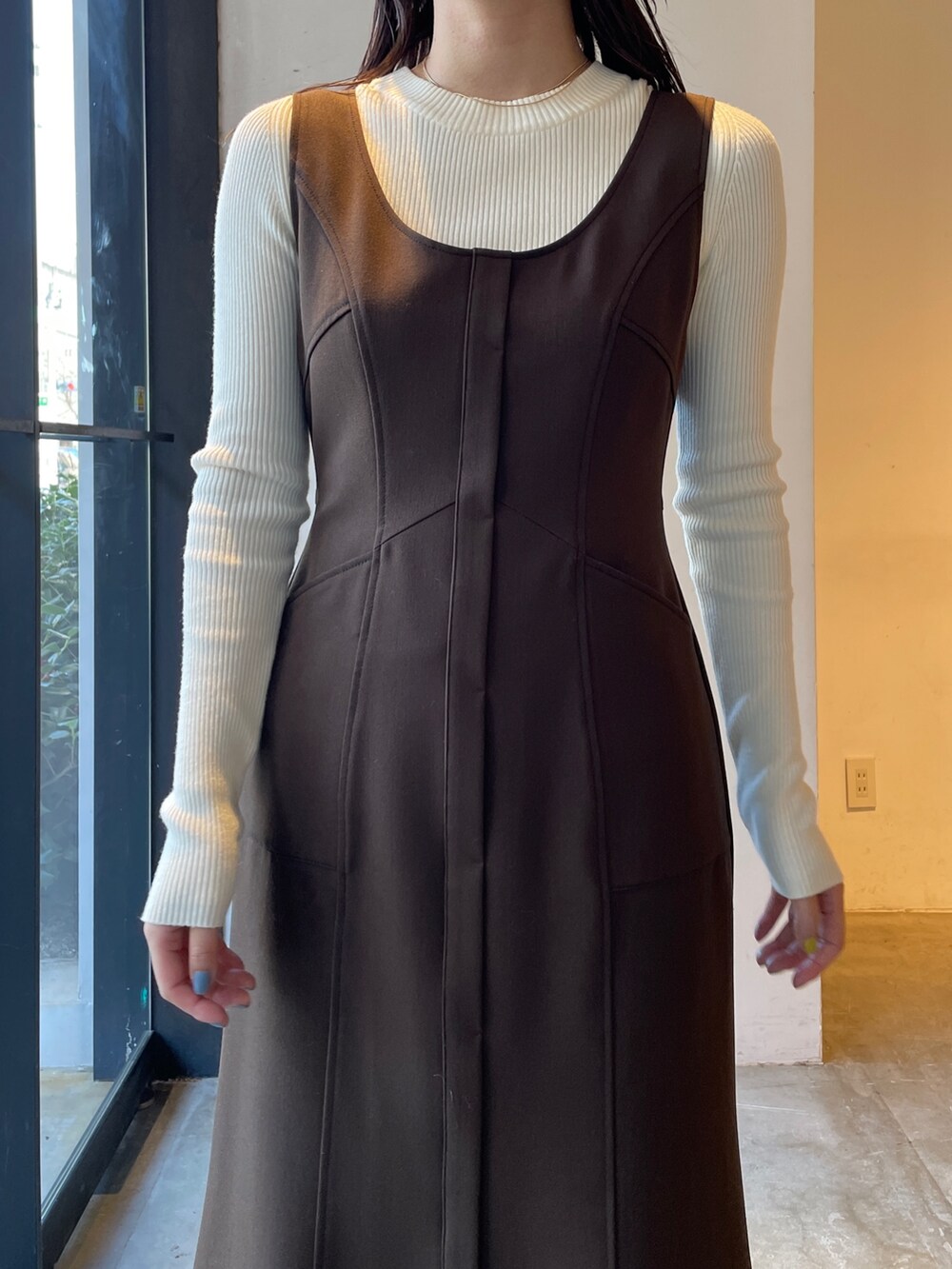 ブラック系のブーツ、ホワイト系のニット/セーター、ブラウン系のジャンパースカートを着用したレディースの冬コーディネートの6枚目の写真