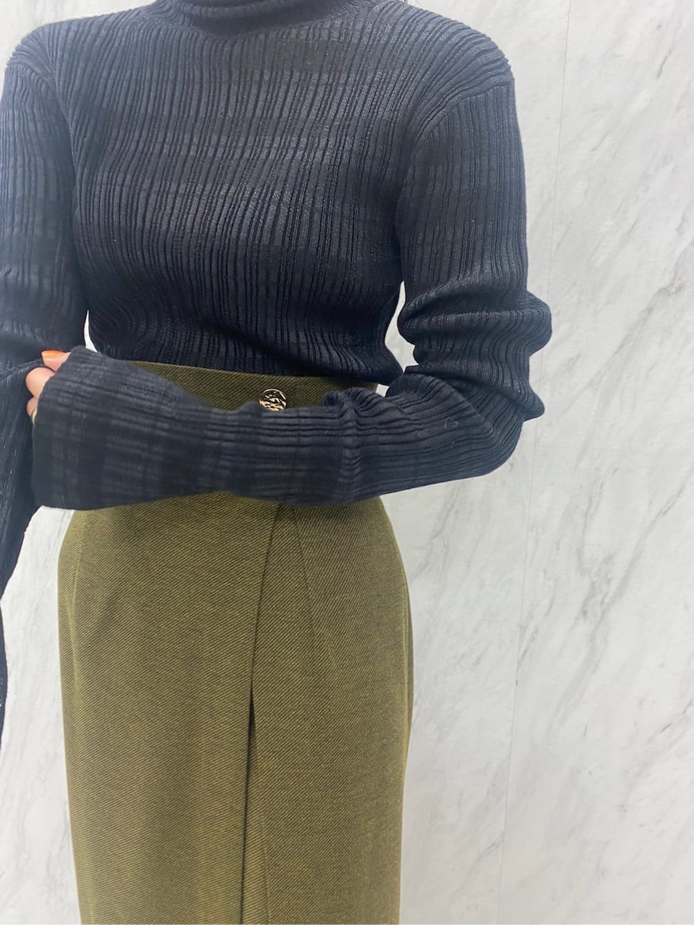 ベージュ系のスカート、ブラック系のニット/セーター、ブラック系のブーツを着用したレディースの夏コーディネートの7枚目の写真