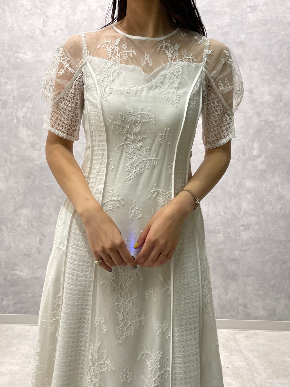 ベージュ系のその他アウター、ゴールド系のパンプス、ホワイト系のドレスを着用したレディースの冬コーディネートの8枚目の写真