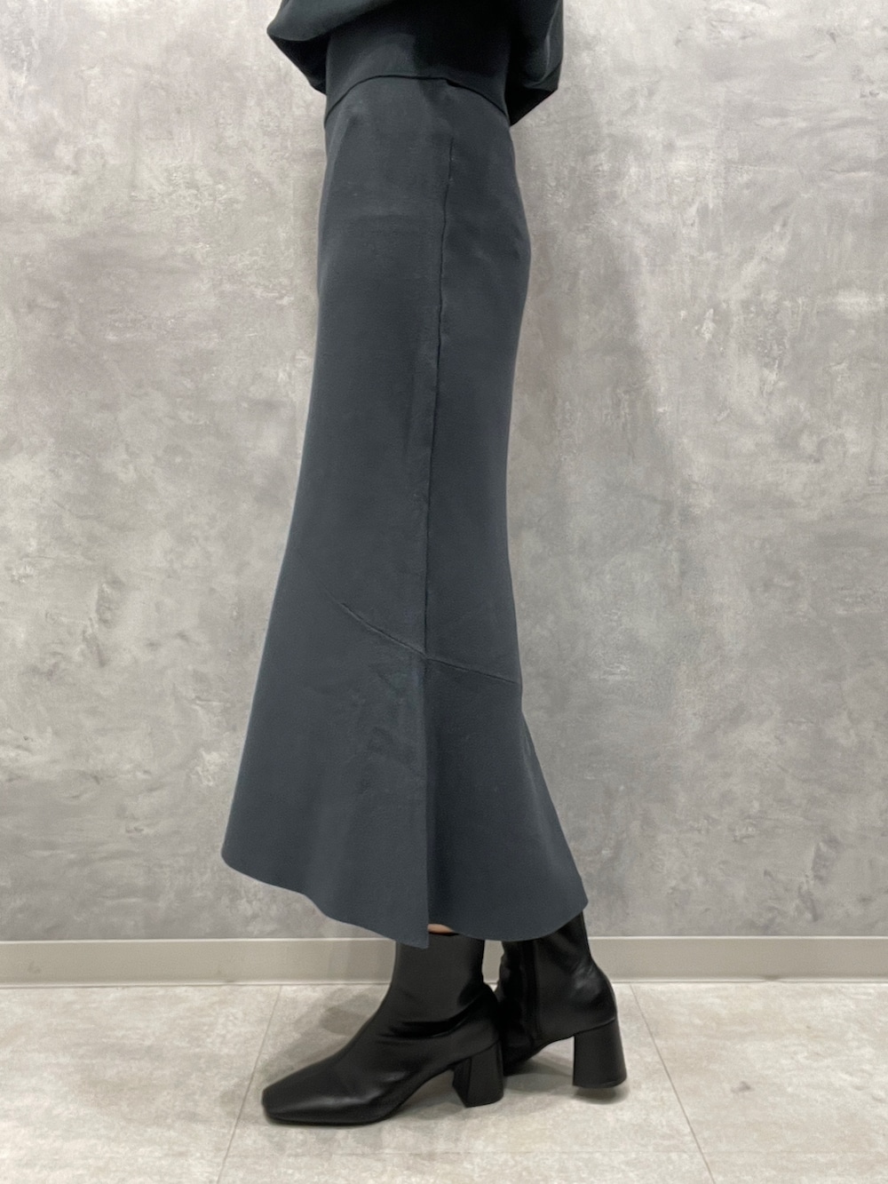 ホワイト系のカーディガン/ボレロ、グリーン系のニット/セーター、グリーン系のスカートを着用したレディースの冬コーディネートの10枚目の写真