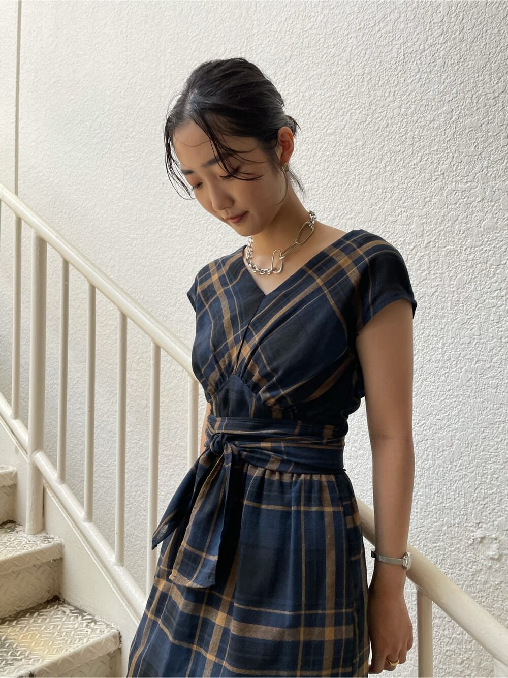 ホワイト系のスニーカー、ブルー系のワンピース、シルバー系のネックレスを着用したレディースの夏コーディネートの3枚目の写真