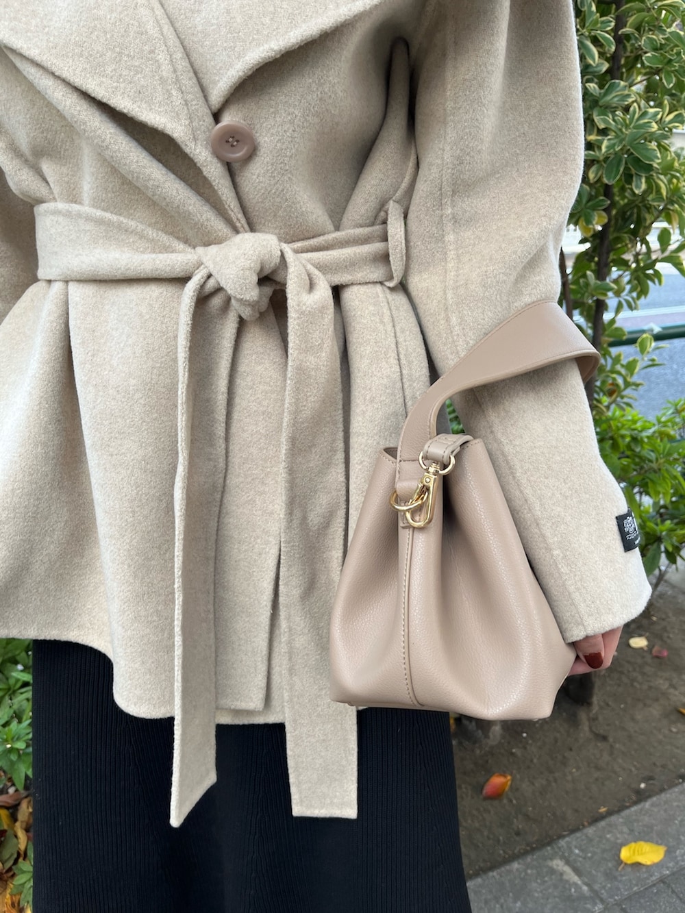 ブラック系のスカート、ブラック系のニット/セーター、グリーン系のブーツを着用したレディースの秋コーディネートの7枚目の写真