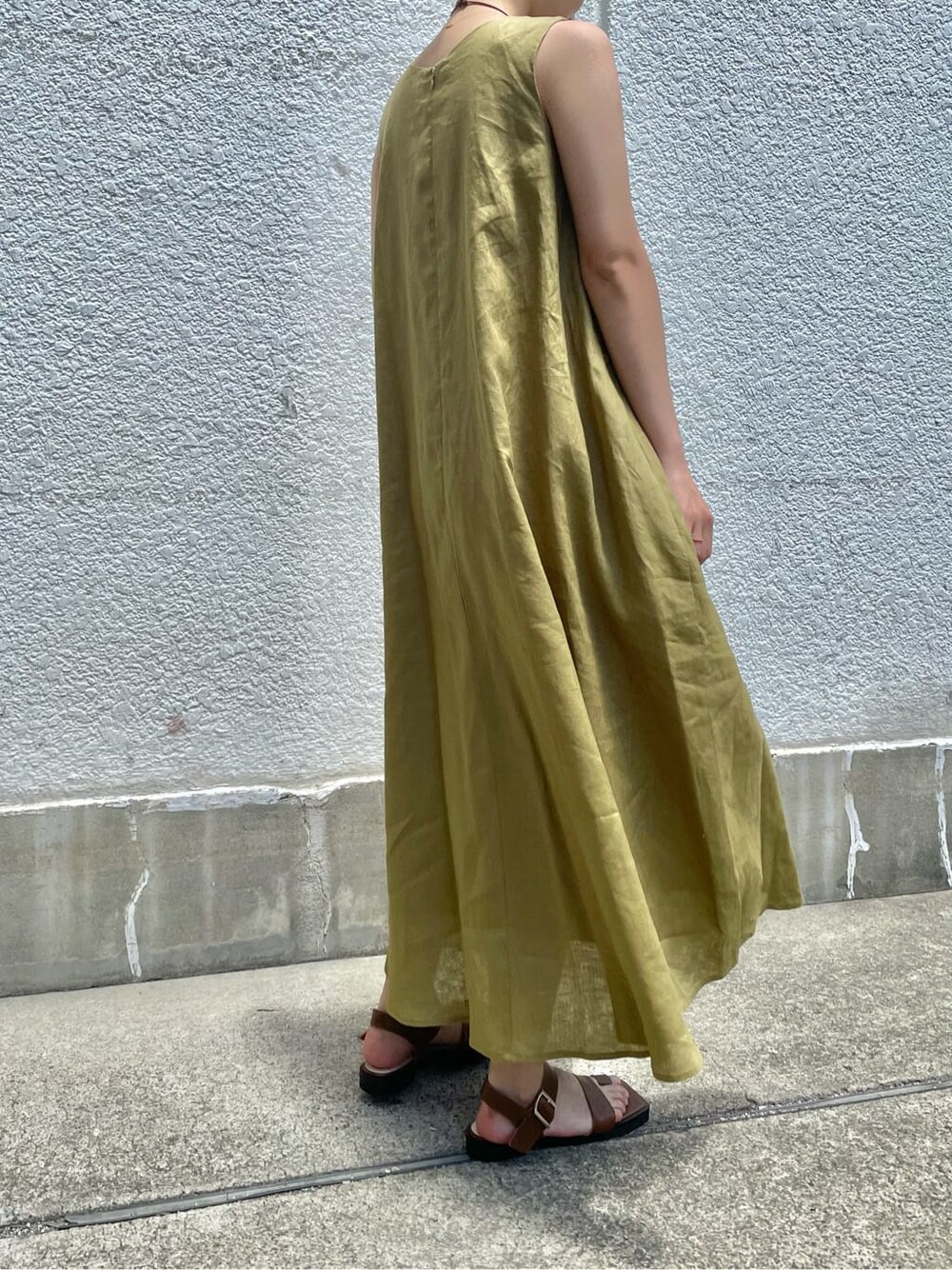 ブラウン系のサンダル、グリーン系のワンピース、ゴールド系のネックレスを着用したレディースの夏コーディネートの4枚目の写真