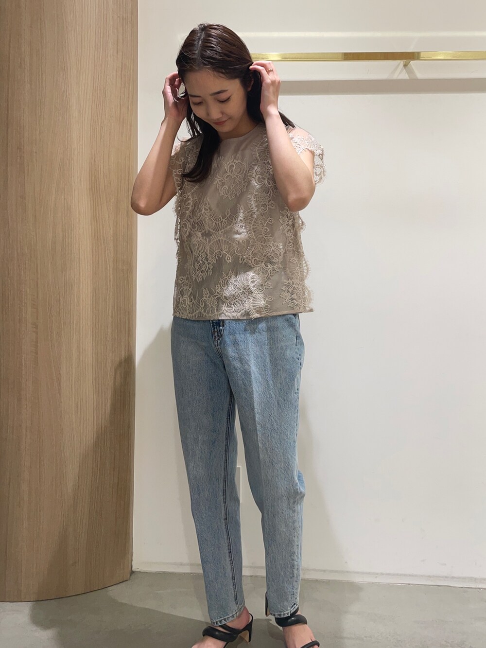 ベージュ系のシャツ/ブラウス、ブルー系のデニムパンツ、ブラック系のサンダルを着用したレディースの春コーディネートの2枚目の写真