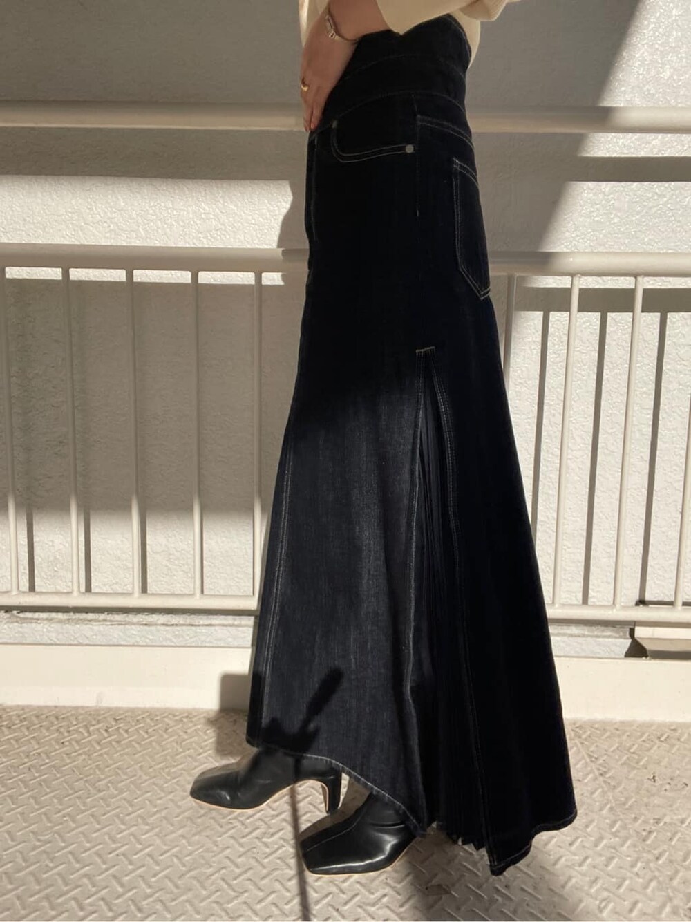 ブラック系のその他シューズ、ブルー系のデニムスカート、ホワイト系のニット/セーターを着用したレディースの冬コーディネートの7枚目の写真