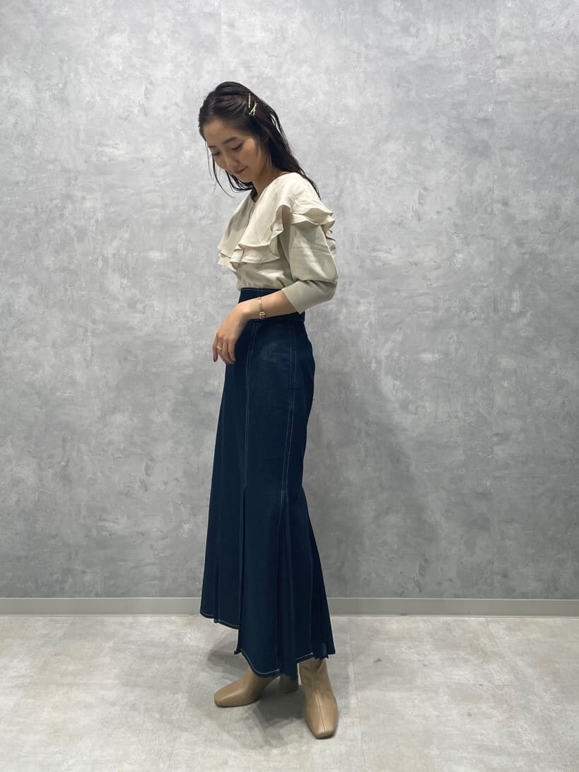 ベージュ系のブーツ、ブルー系のスカート、ホワイト系のニット/セーターを着用したレディースの秋コーディネートの5枚目の写真