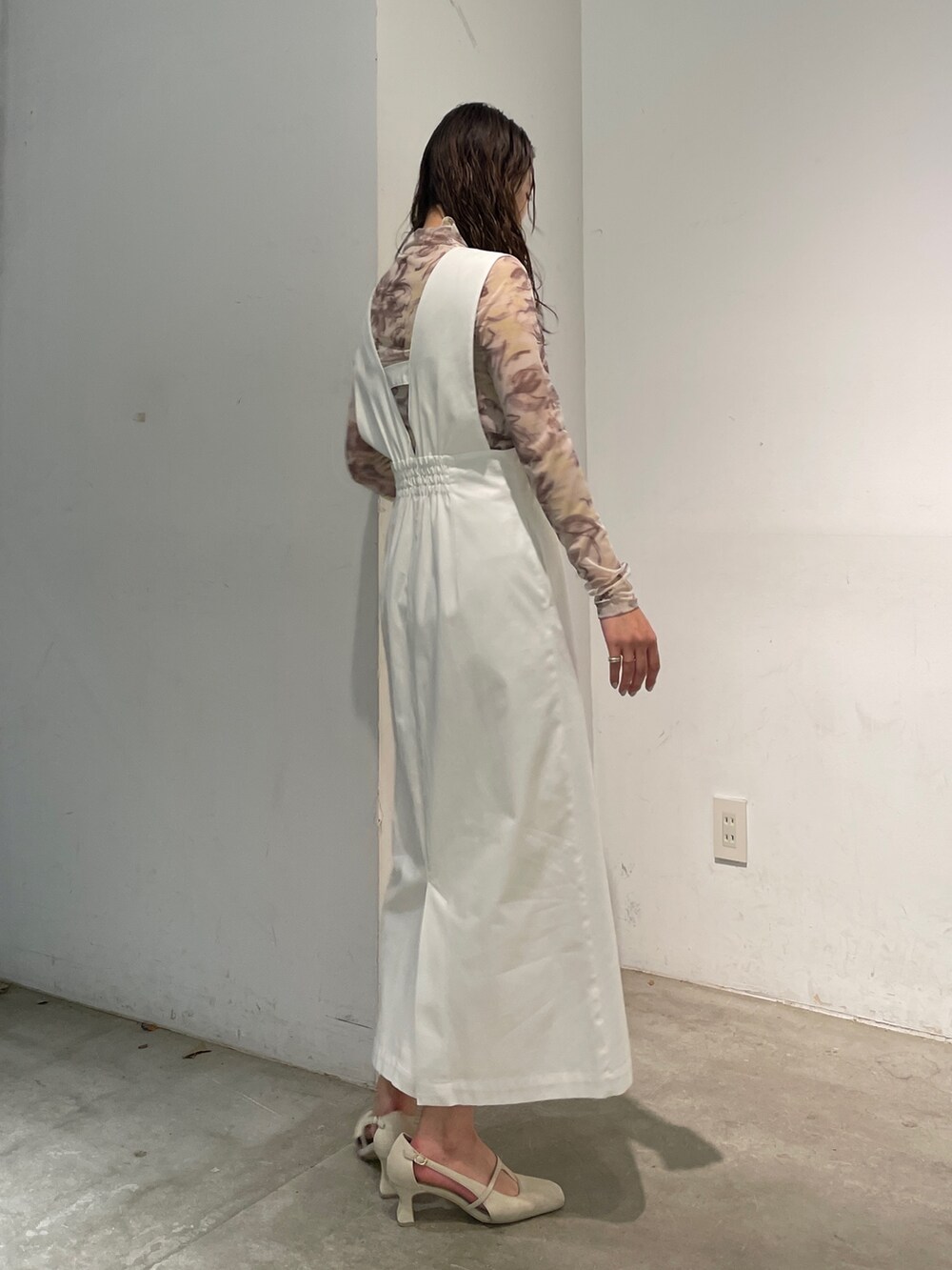 ホワイト系のパンプス、イエロー系のTシャツ/カットソー、ホワイト系のジャンパースカートを着用したレディースの冬コーディネートの5枚目の写真