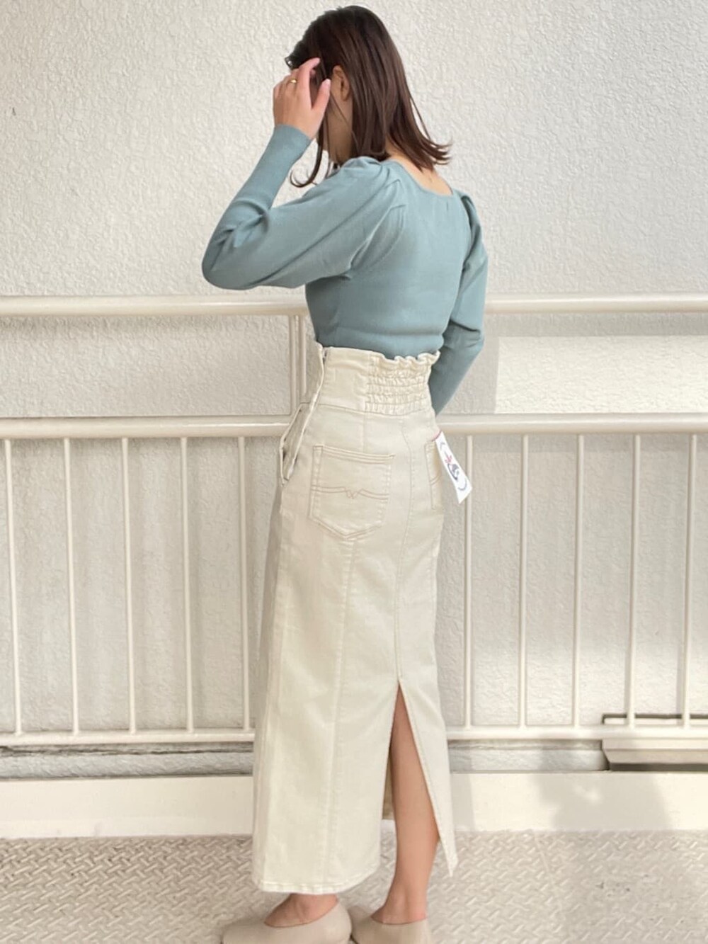 ホワイト系のブルゾン、ホワイト系のスカート、ホワイト系のパンプスを着用したレディースの冬コーディネートの7枚目の写真