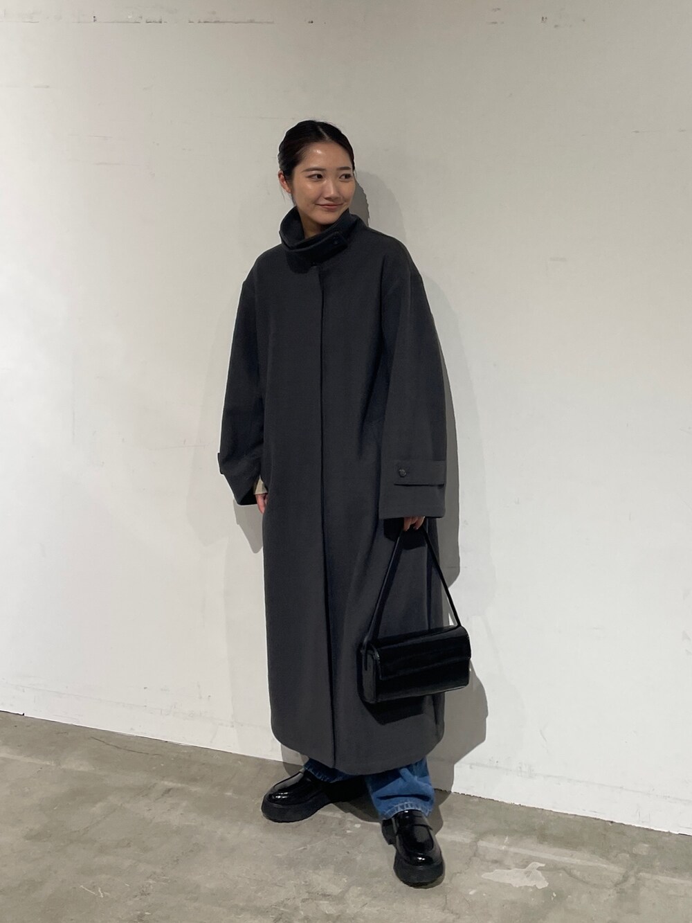 ブルー系のデニムパンツ、グレー系のステンカラーコート、ブラック系のローファーを着用したレディースの夏コーディネートの3枚目の写真
