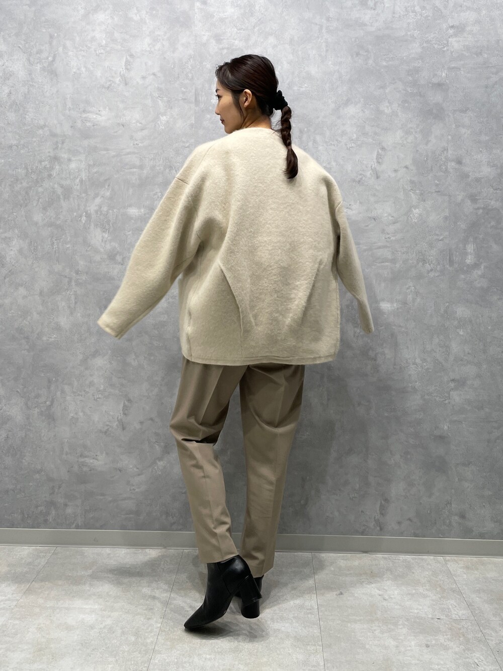 ブラック系のブーツ、ベージュ系のその他パンツ、ホワイト系のカーディガン/ボレロを着用したレディースの冬コーディネートの3枚目の写真