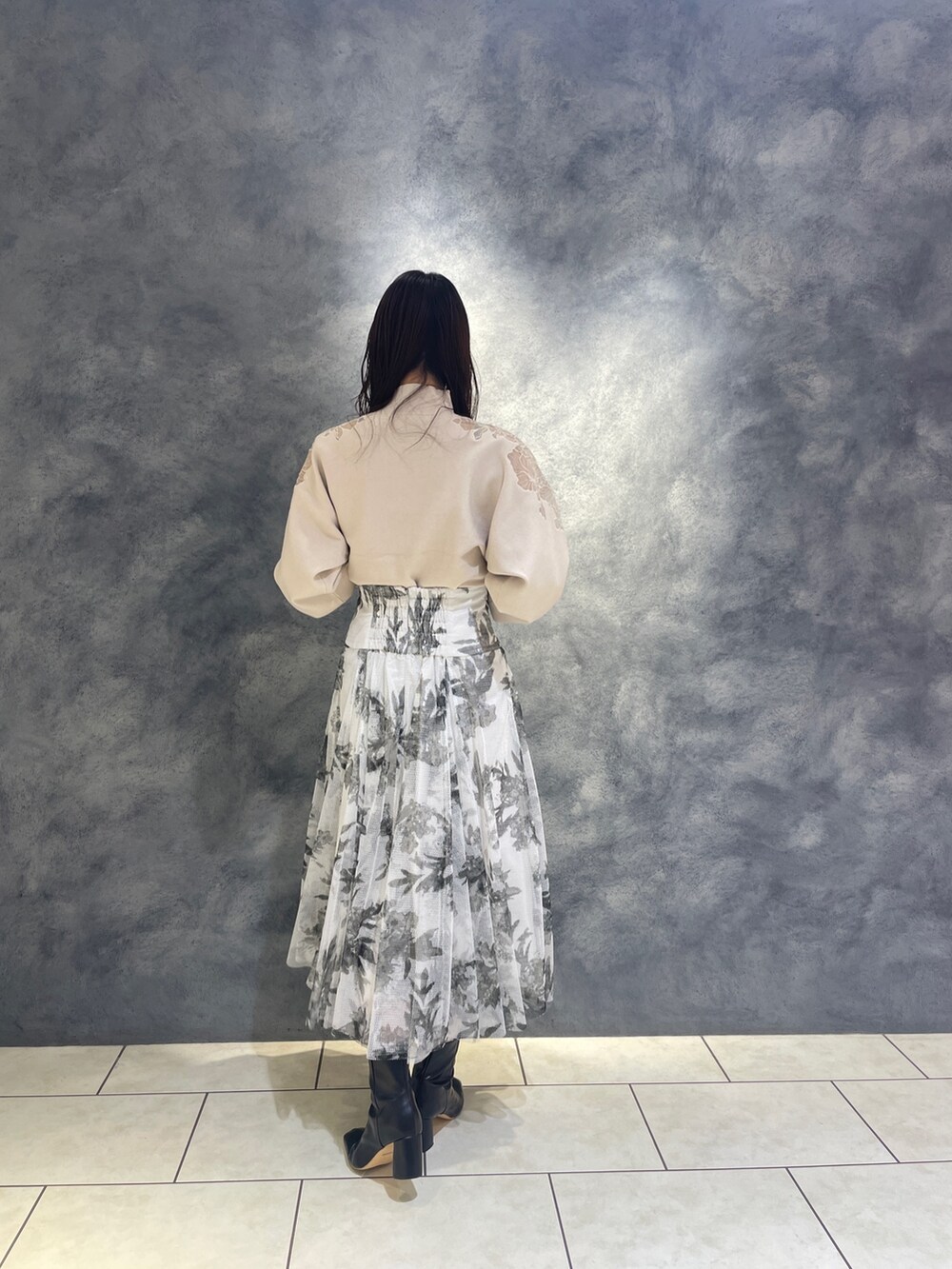 ホワイト系のニット/セーター、ブラック系のブーツ、ブラック系のスカートを着用したレディースの秋コーディネートの6枚目の写真