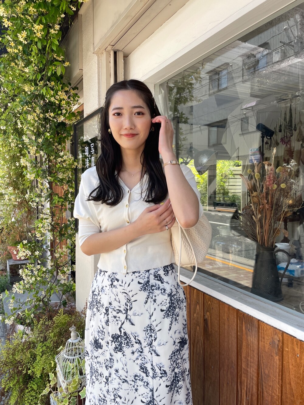 ベージュ系のハンドバッグ、ホワイト系のカーディガン/ボレロ、ブルー系のスカートを着用したレディースの春コーディネートの4枚目の写真