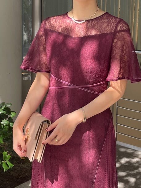 レッド系のドレス、ゴールド系のクラッチバッグ、ゴールド系のパンプスを着用したレディースの秋コーディネートの6枚目の写真