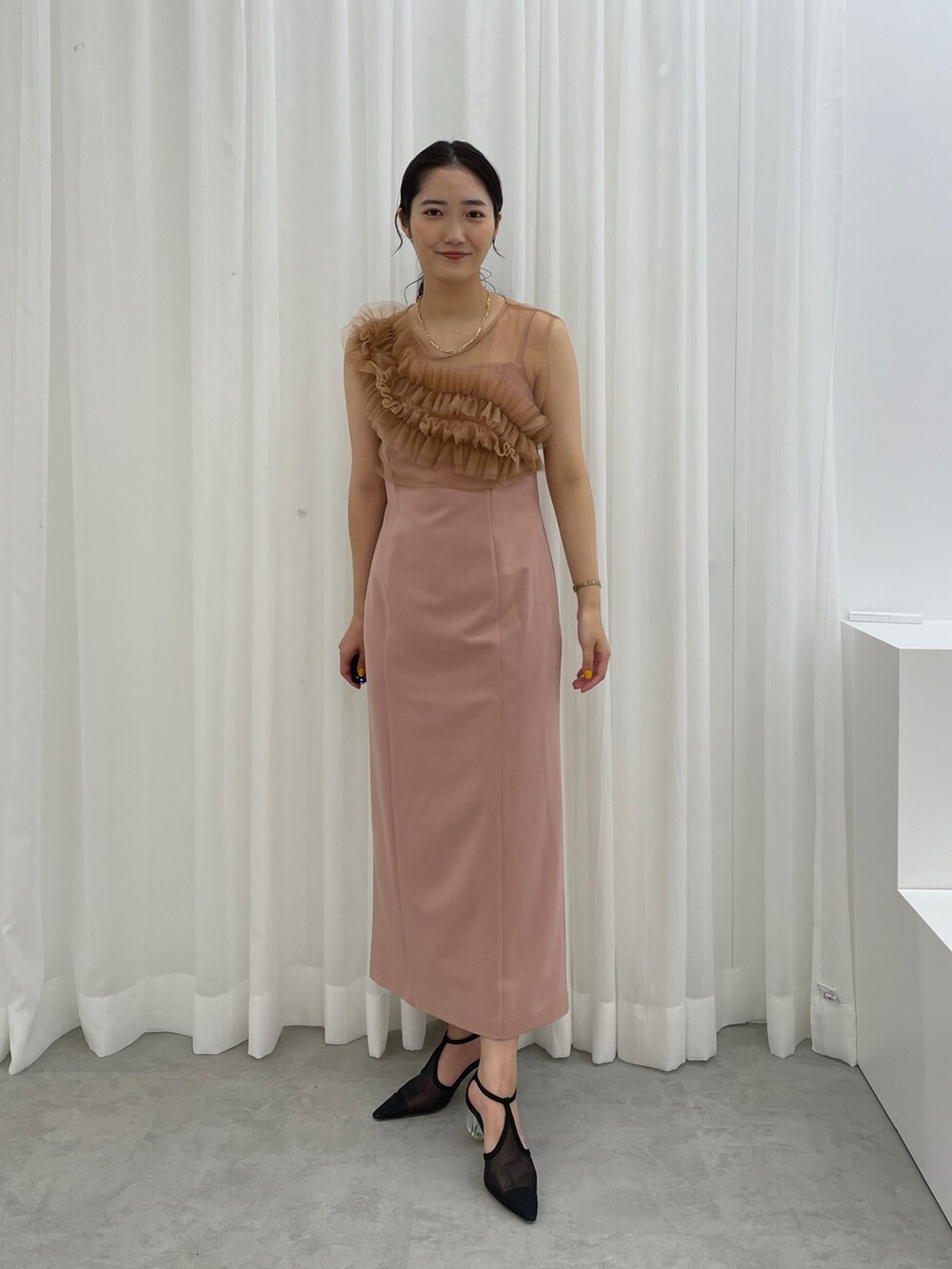 ブラック系のパンプス、ピンク系のドレスを着用したレディースの春コーディネートの4枚目の写真